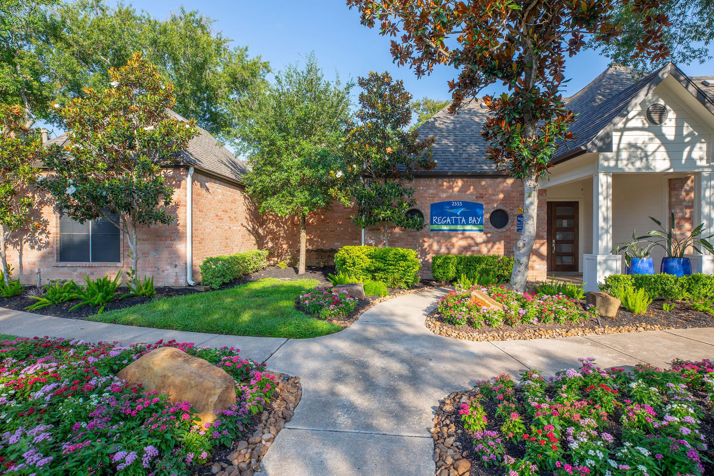 a close up of a flower garden in front of a house