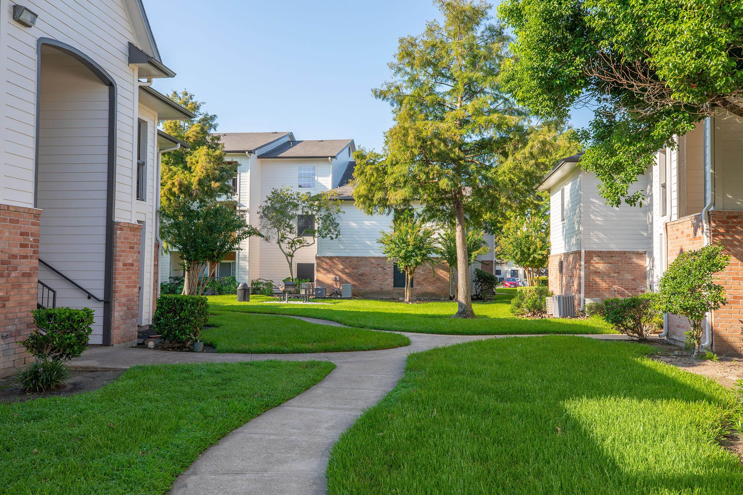 a house with a lawn in front of a brick building