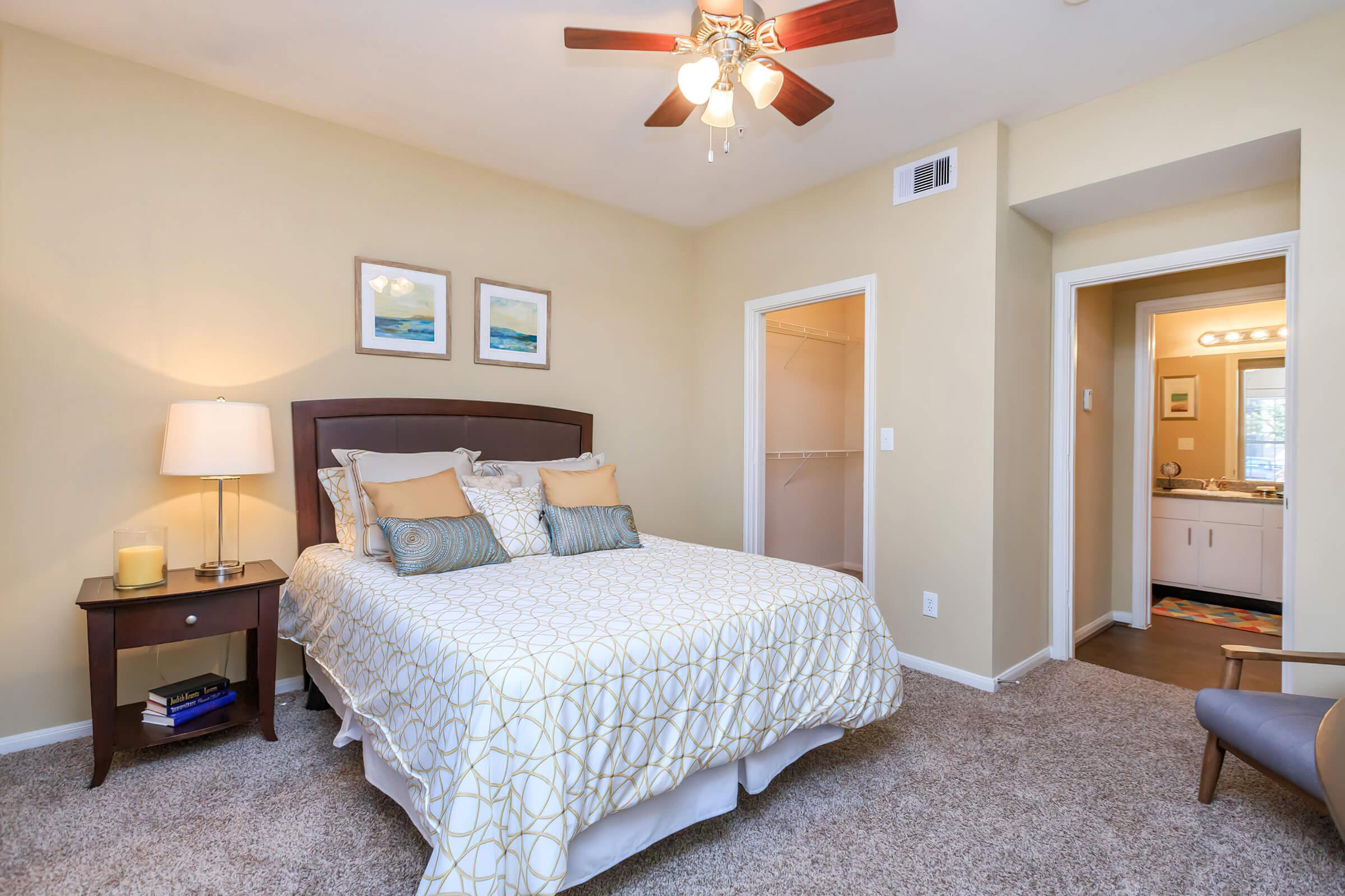 a bedroom with a bed and desk in a hotel room