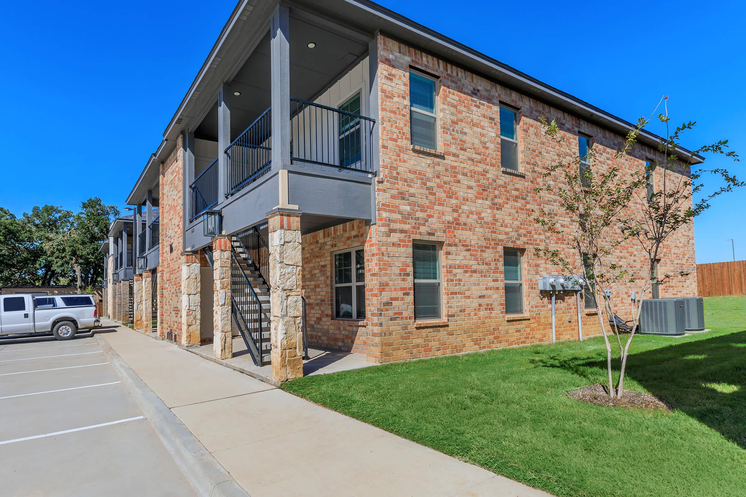 a large lawn in front of a brick building