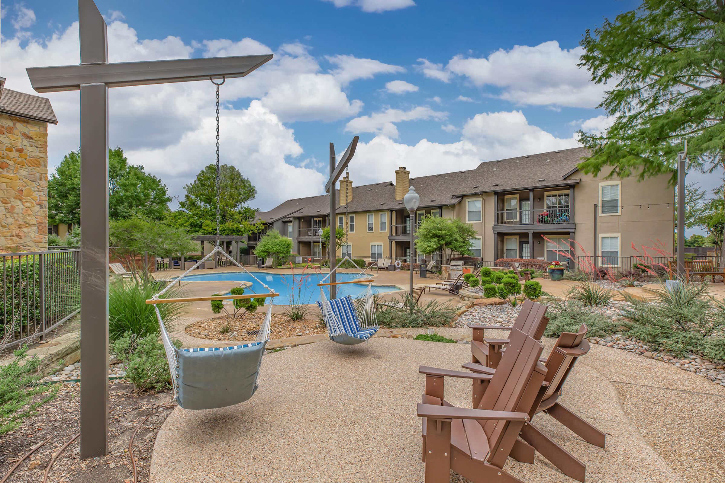 the community pool with green bushes