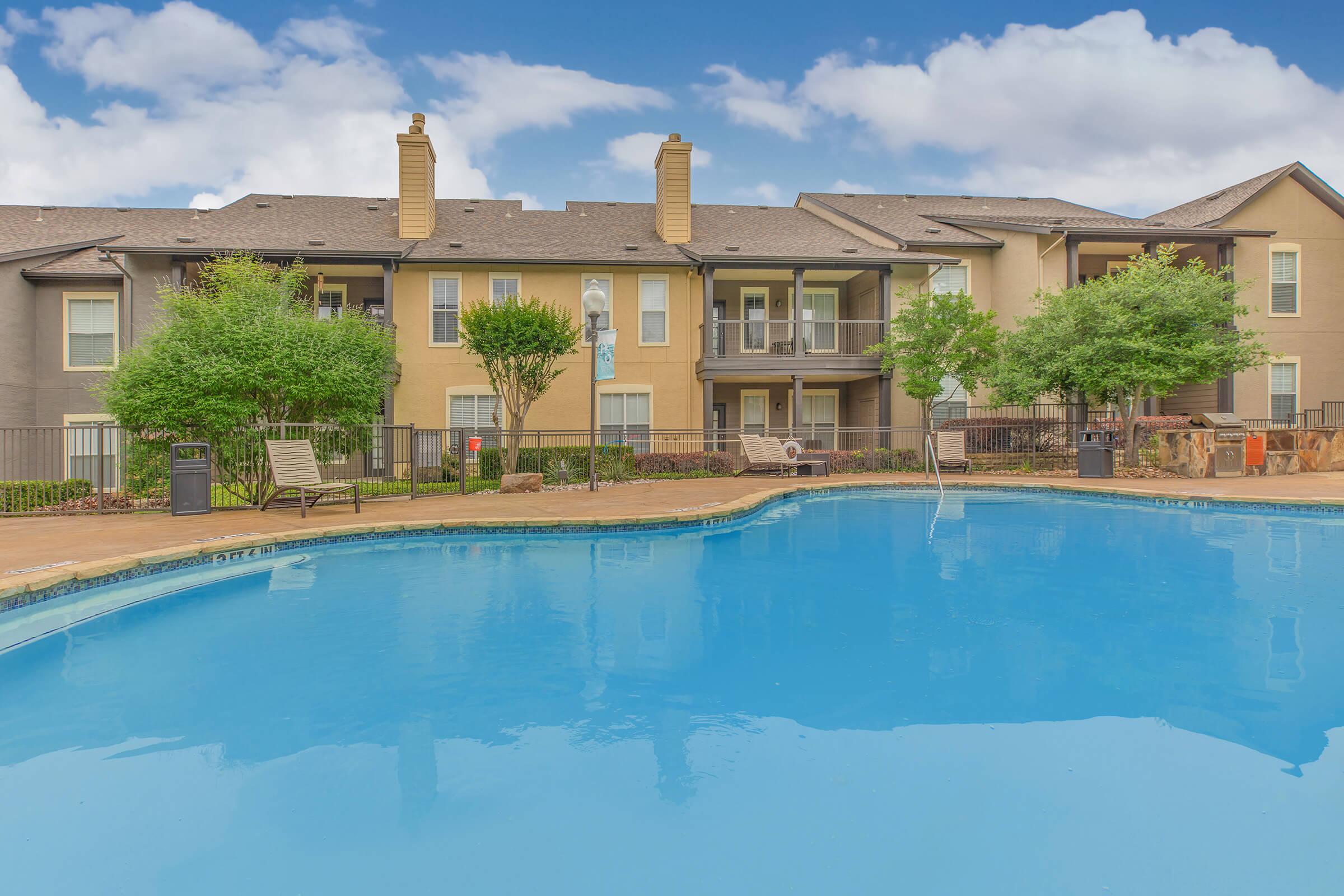 a community pool with a green trees