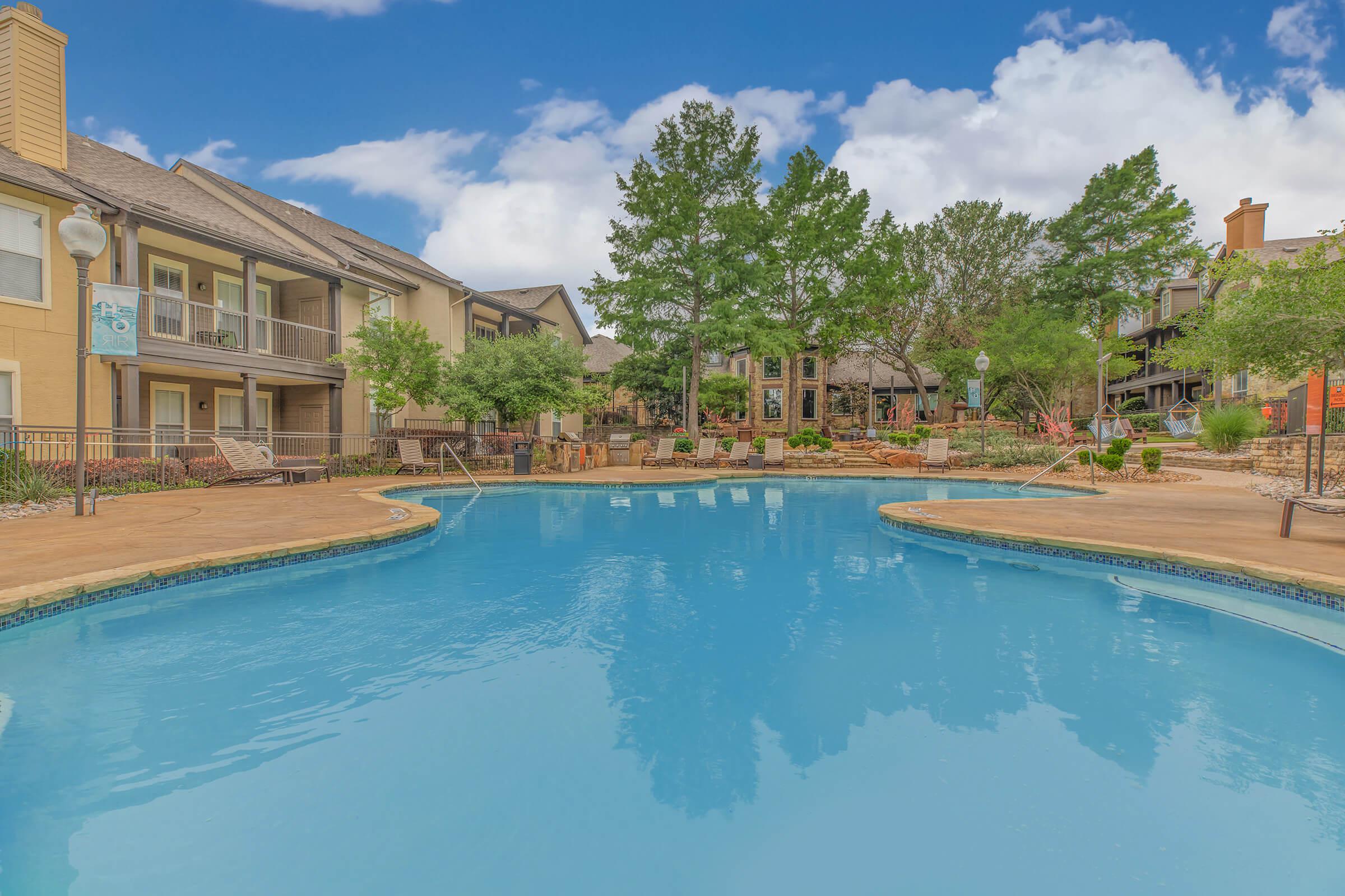 The Ranch at Ridgeview Apartments community pool with green bushes