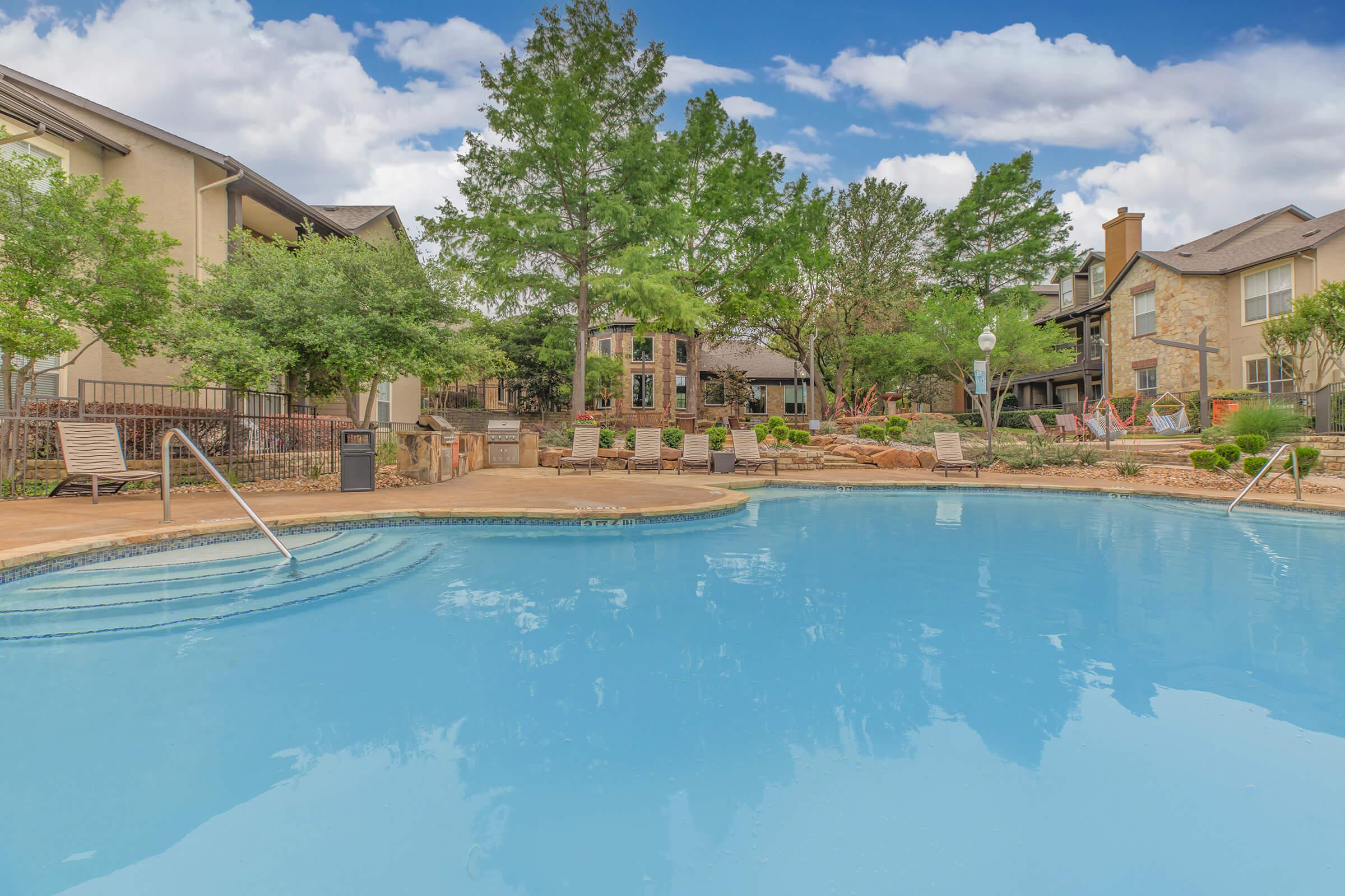 the community pool with green trees