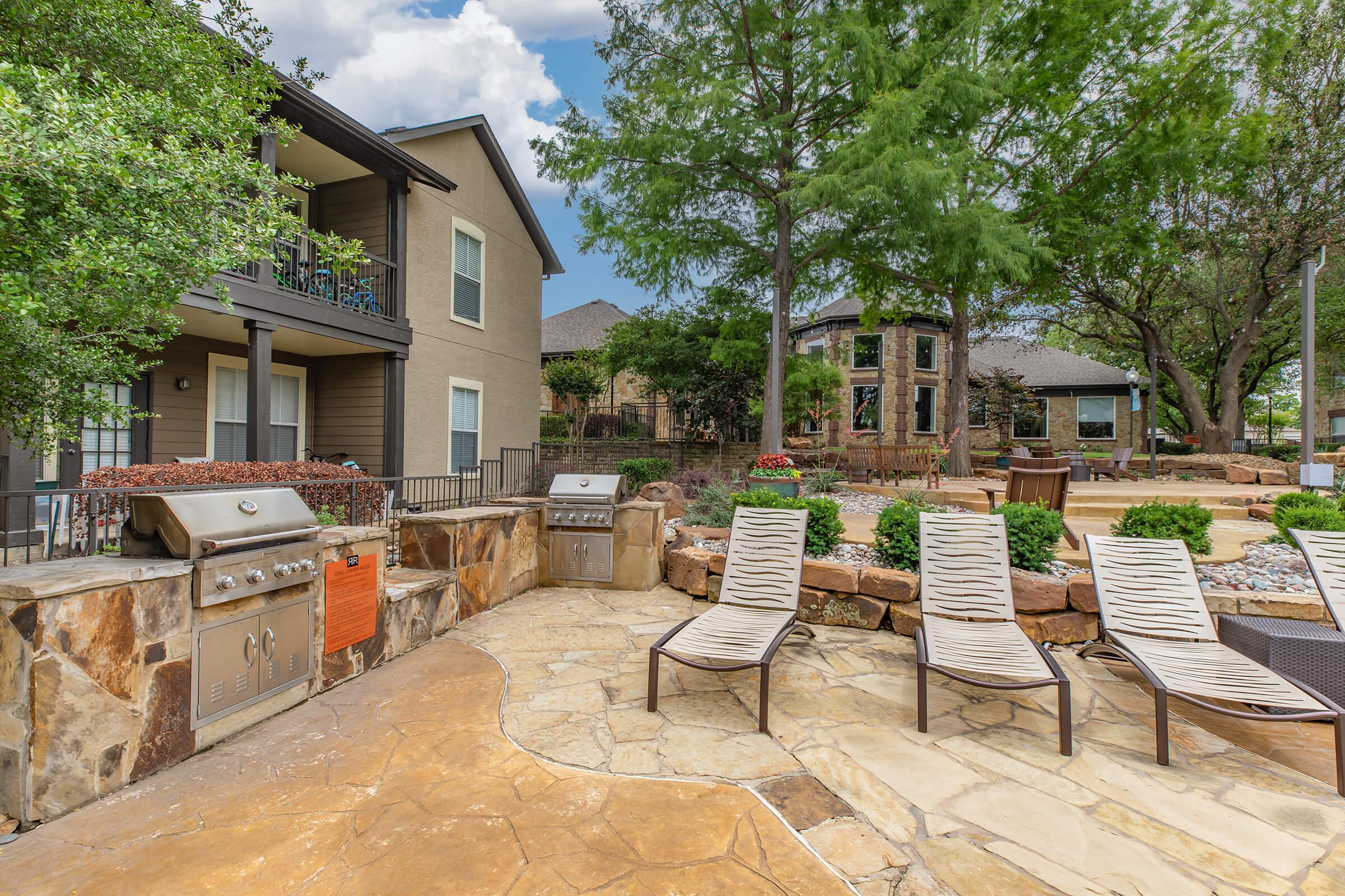 stainless steel barbecues next to pool chairs