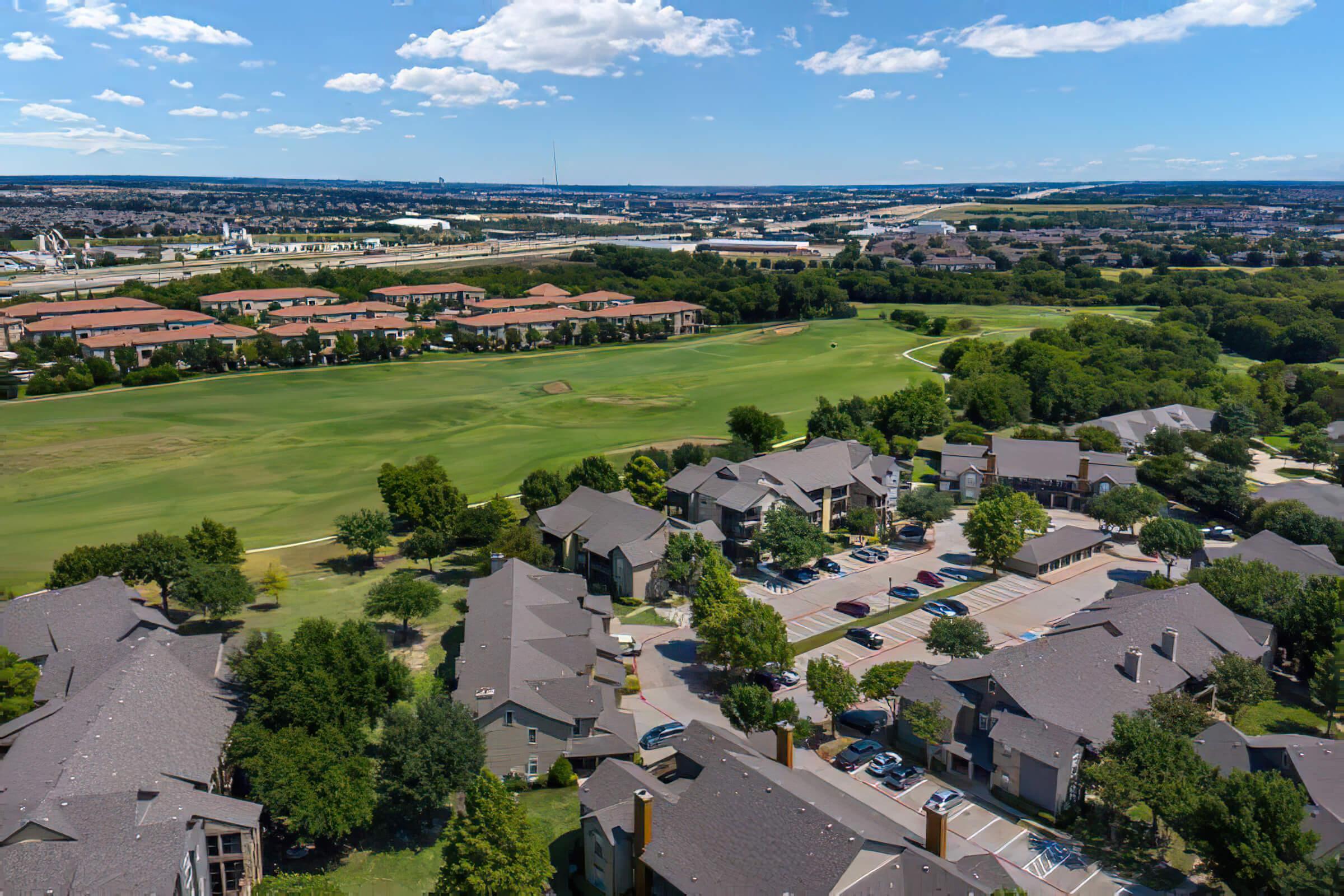 a green field next to the community apartments