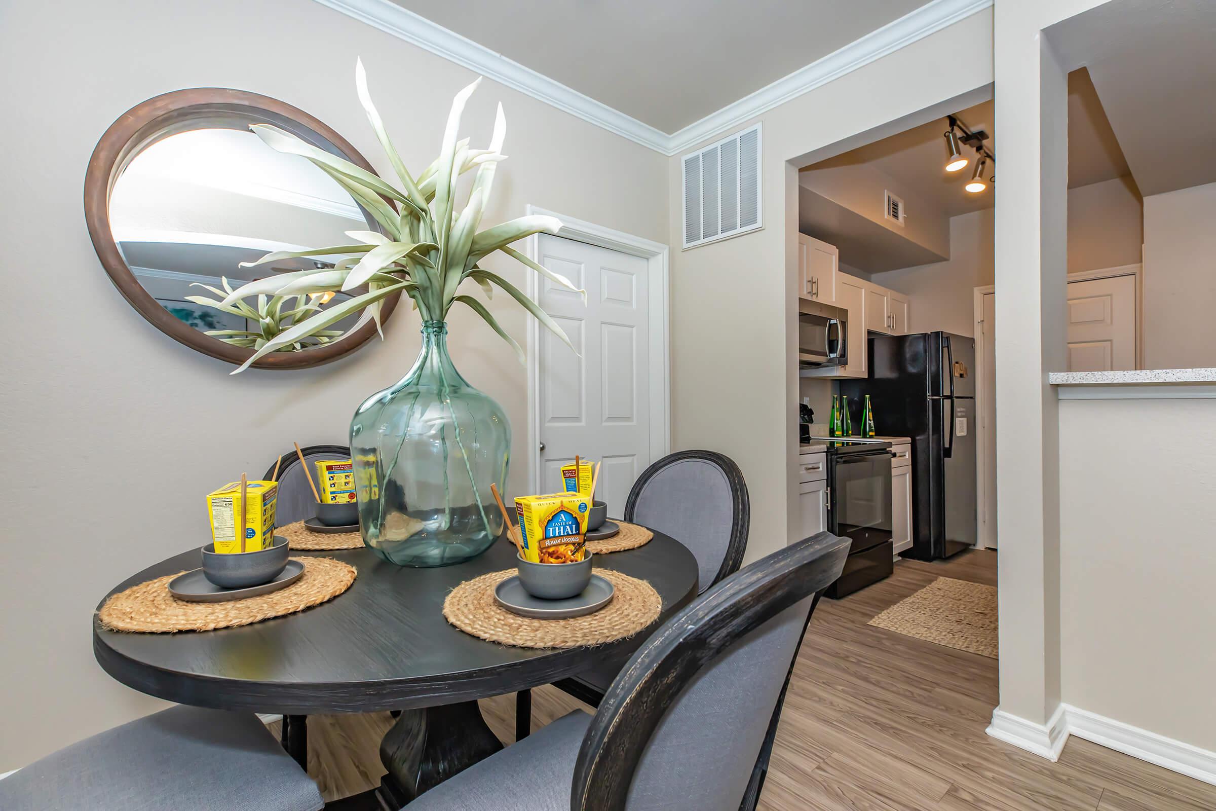 a dining room and kitchen with wooden floors