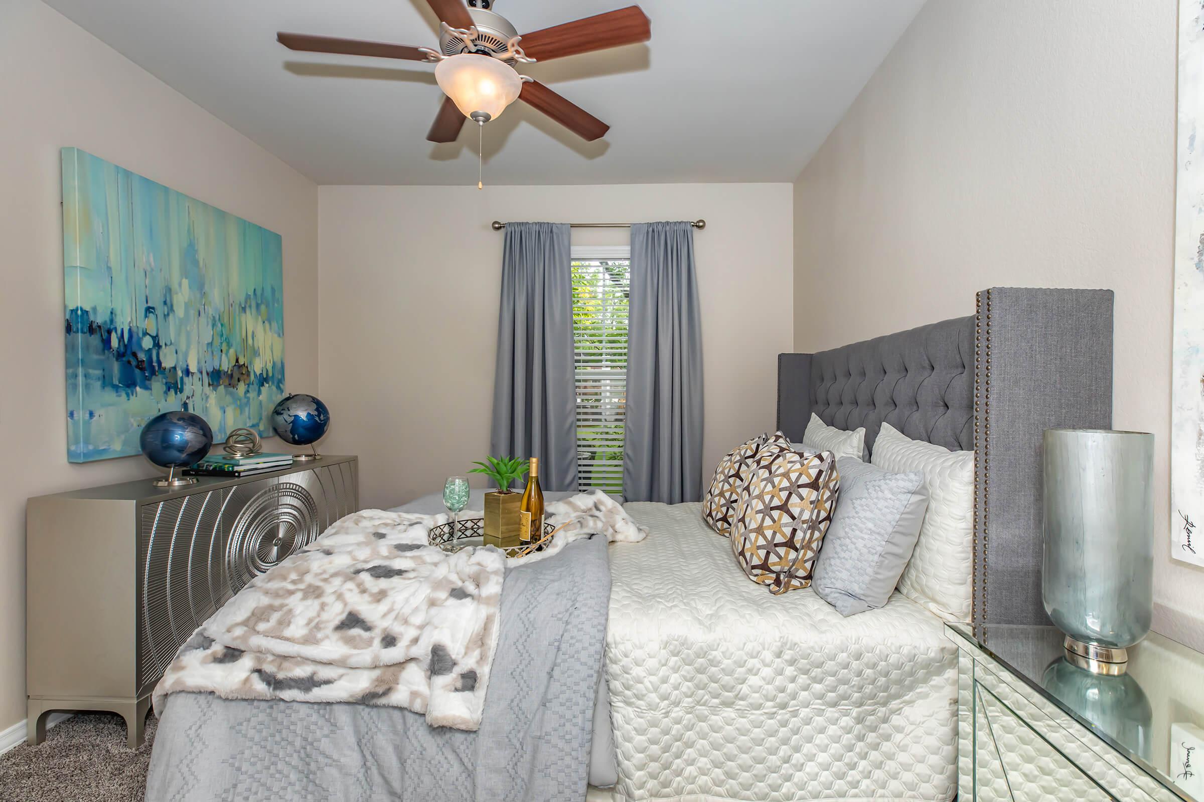a bedroom with a grey comforter