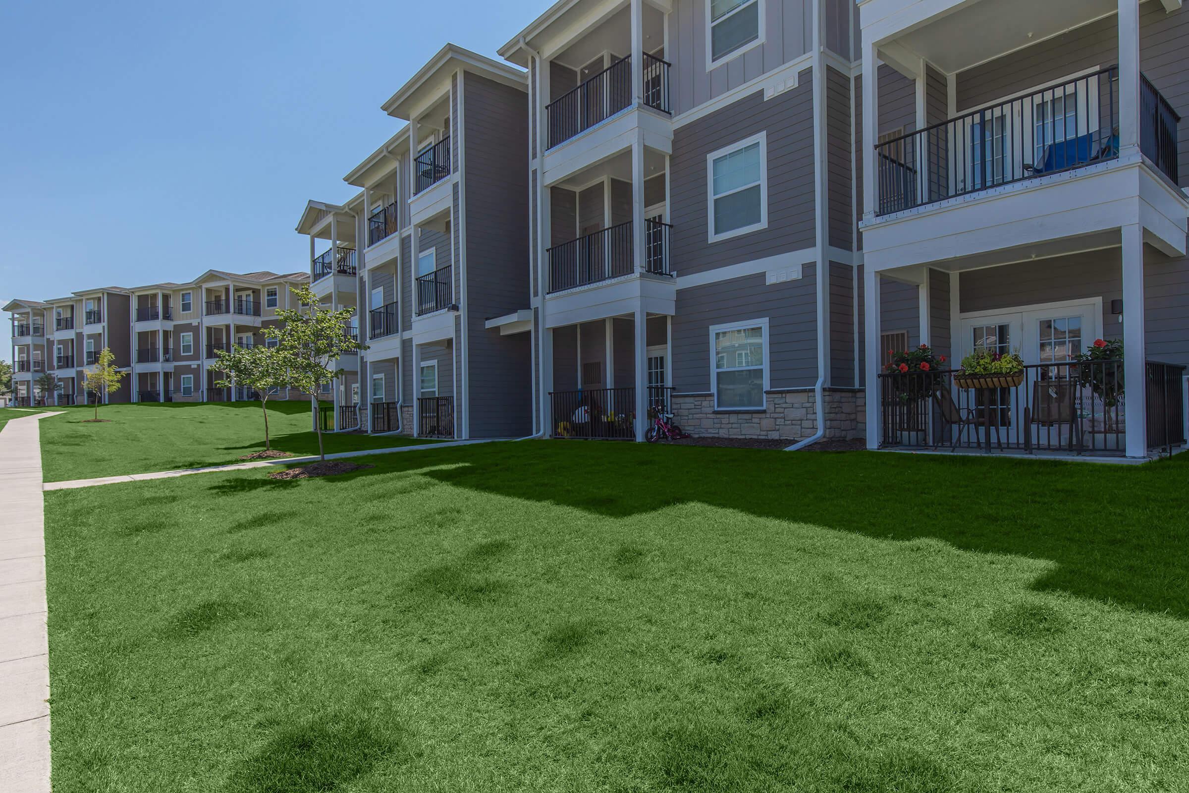 a large lawn in front of a brick building