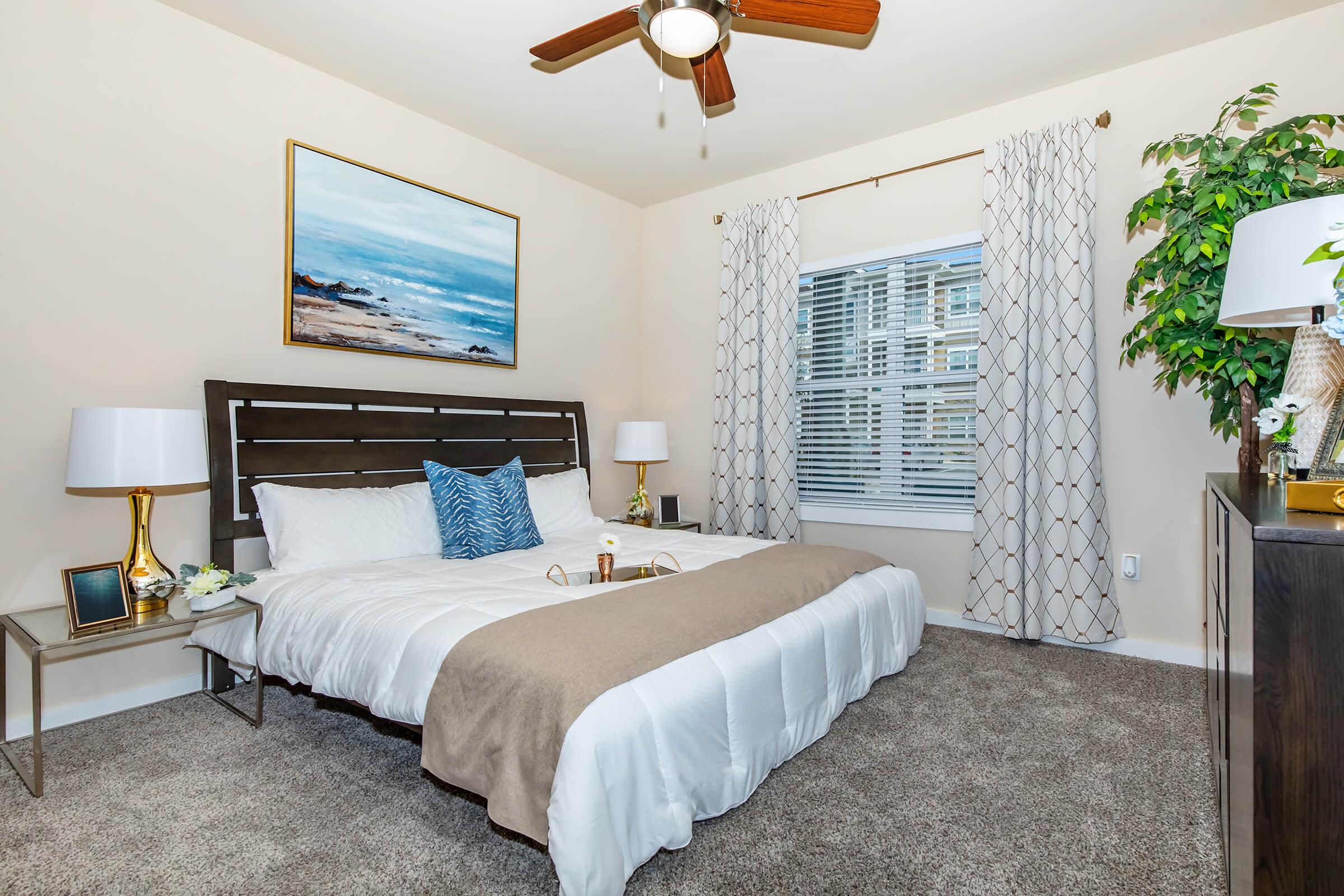 a bedroom with a bed and desk in a hotel room