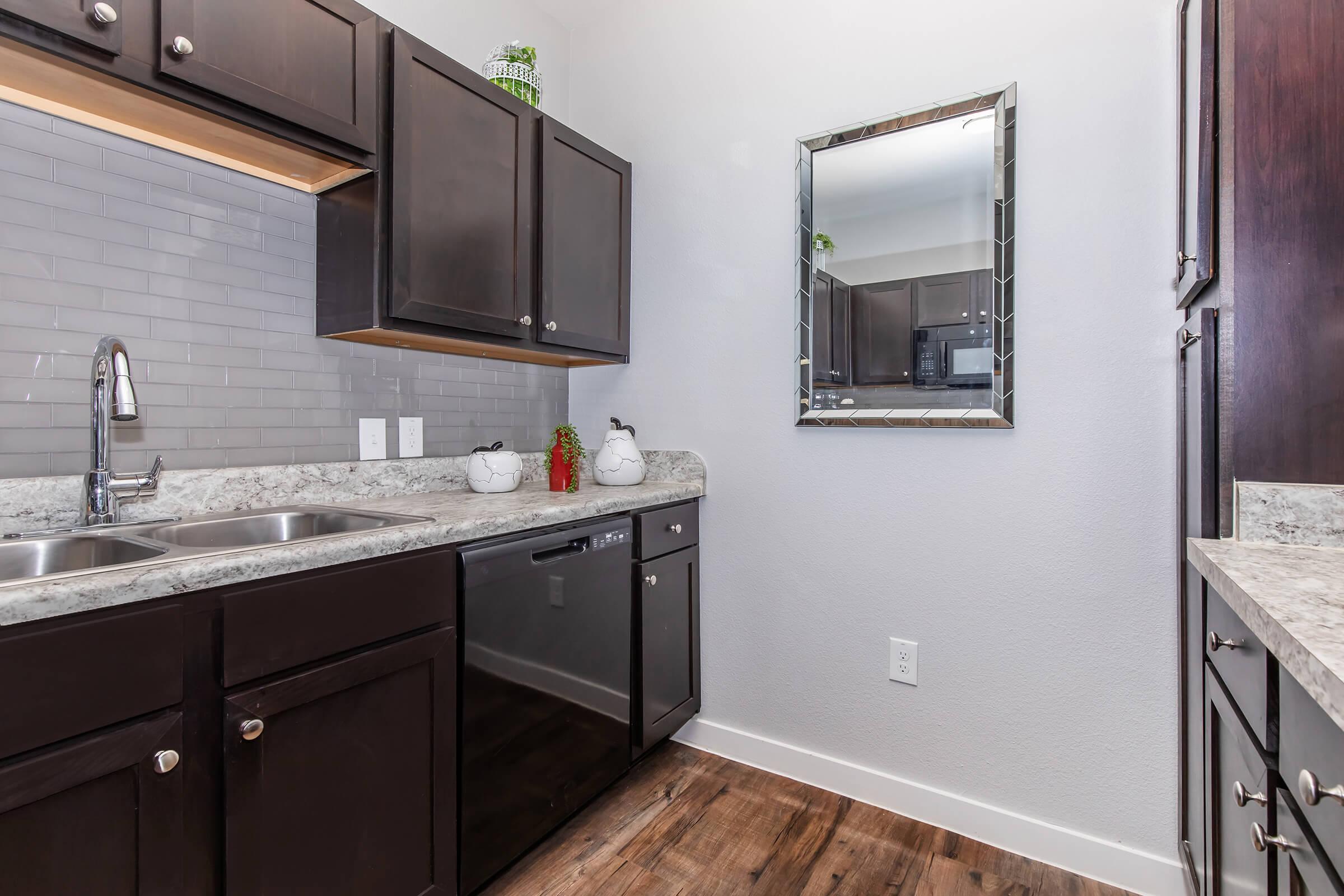 a kitchen with a sink and a mirror