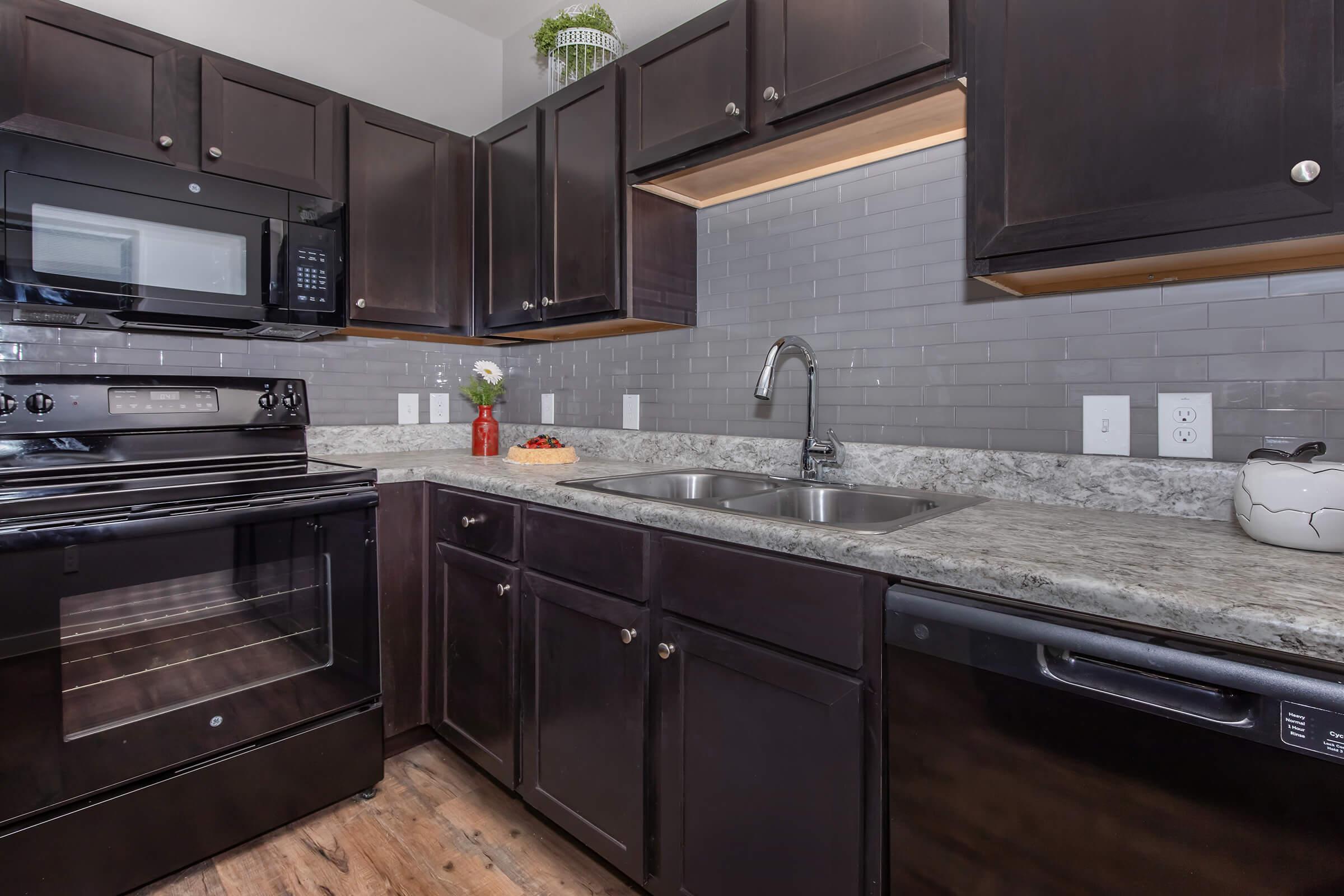 a large kitchen with stainless steel appliances and wooden cabinets