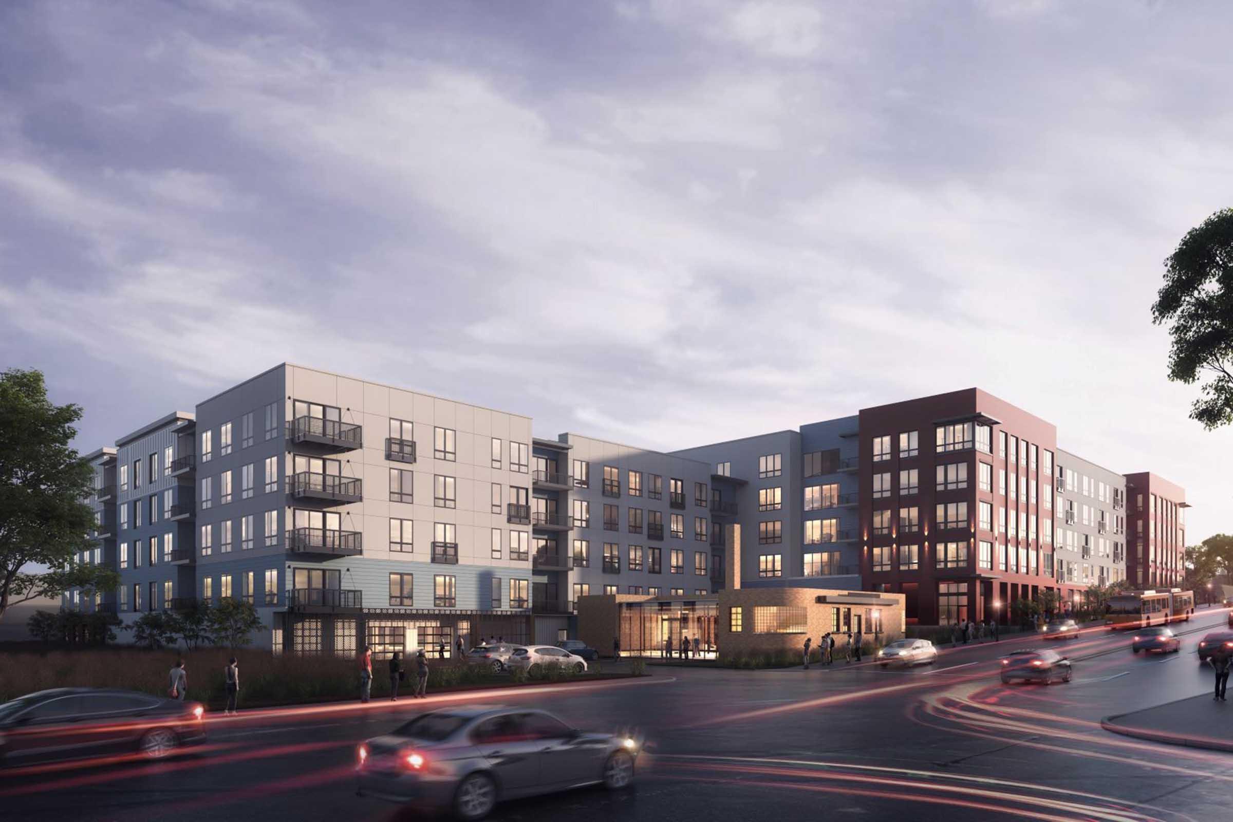 Modern apartment complex with multiple buildings featuring contemporary architecture. Large glass windows, balconies, and a variety of exterior materials. A busy street runs in front, with vehicles and trees nearby. The sky is overcast, creating a serene atmosphere.