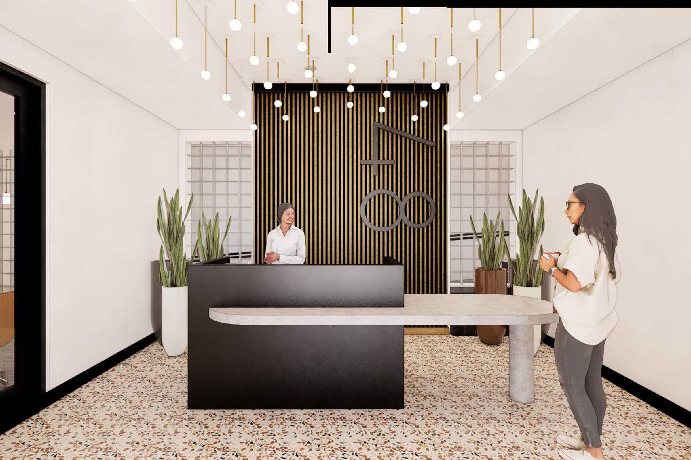 Modern reception area featuring a sleek black front desk, a friendly receptionist, and elegant pendant lighting. The space includes decorative indoor plants and stylish flooring with a terrazzo pattern, creating a welcoming and contemporary atmosphere. A person is standing, holding a phone, and engaging with the receptionist.