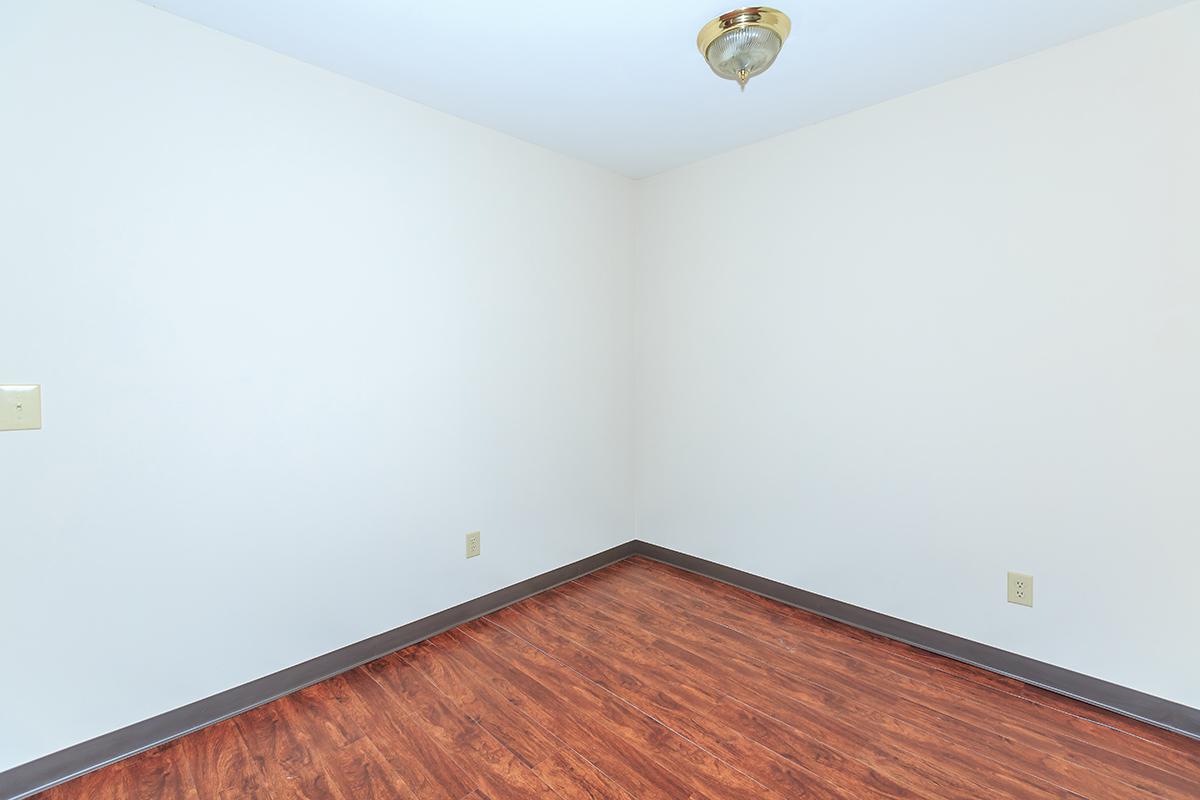 a bedroom with a wooden floor