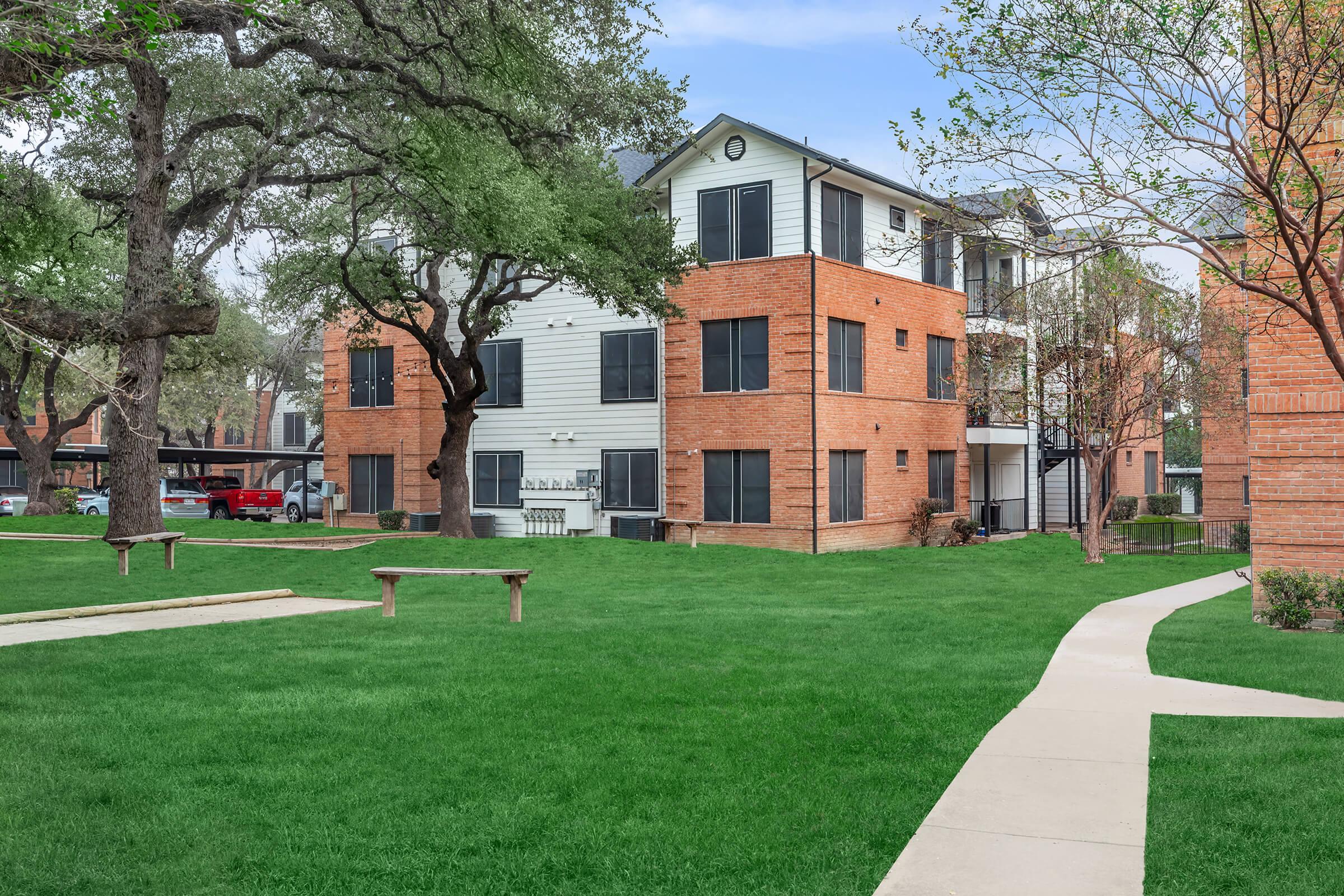 a large lawn in front of a brick building