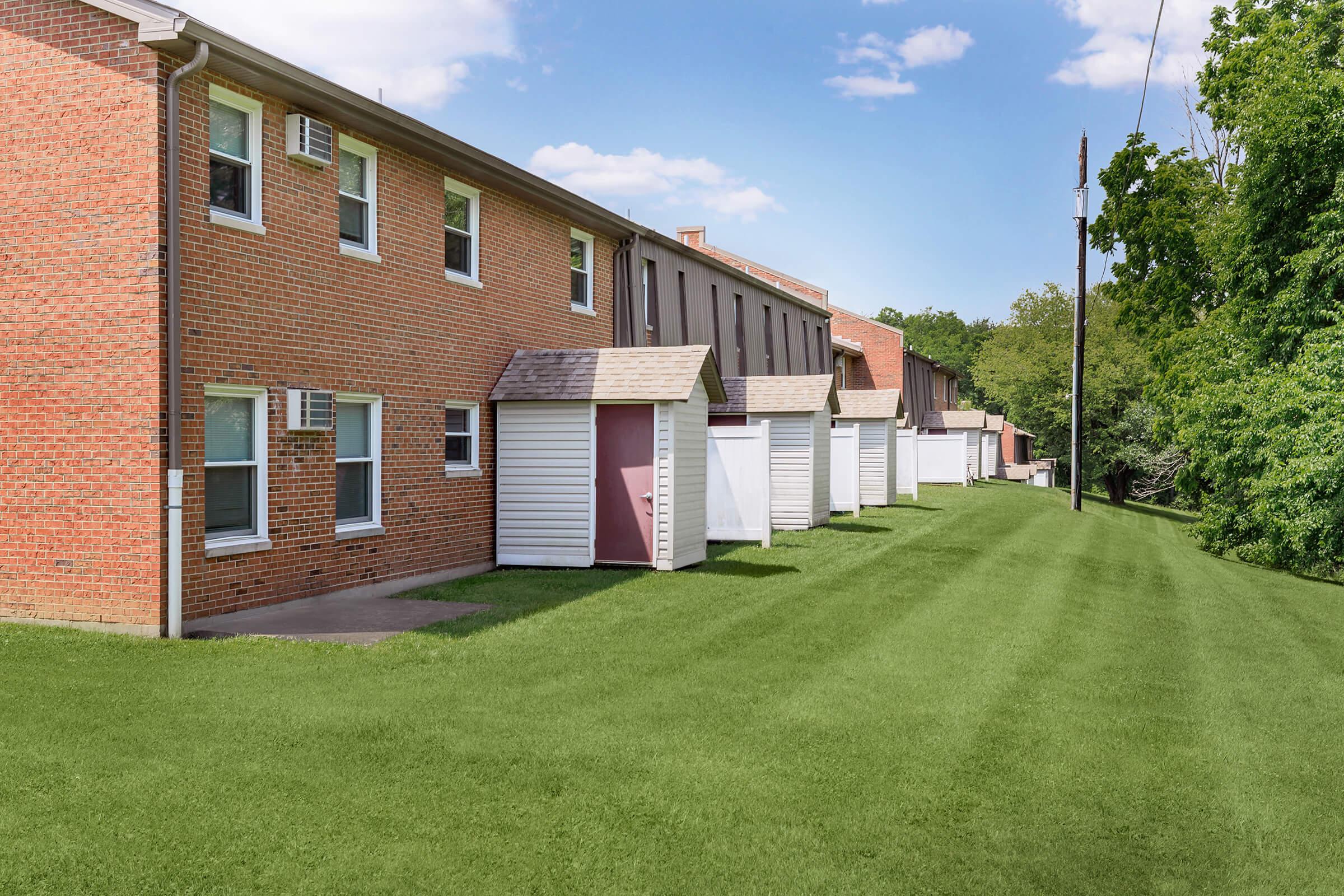 a large brick building with grass in front of a house