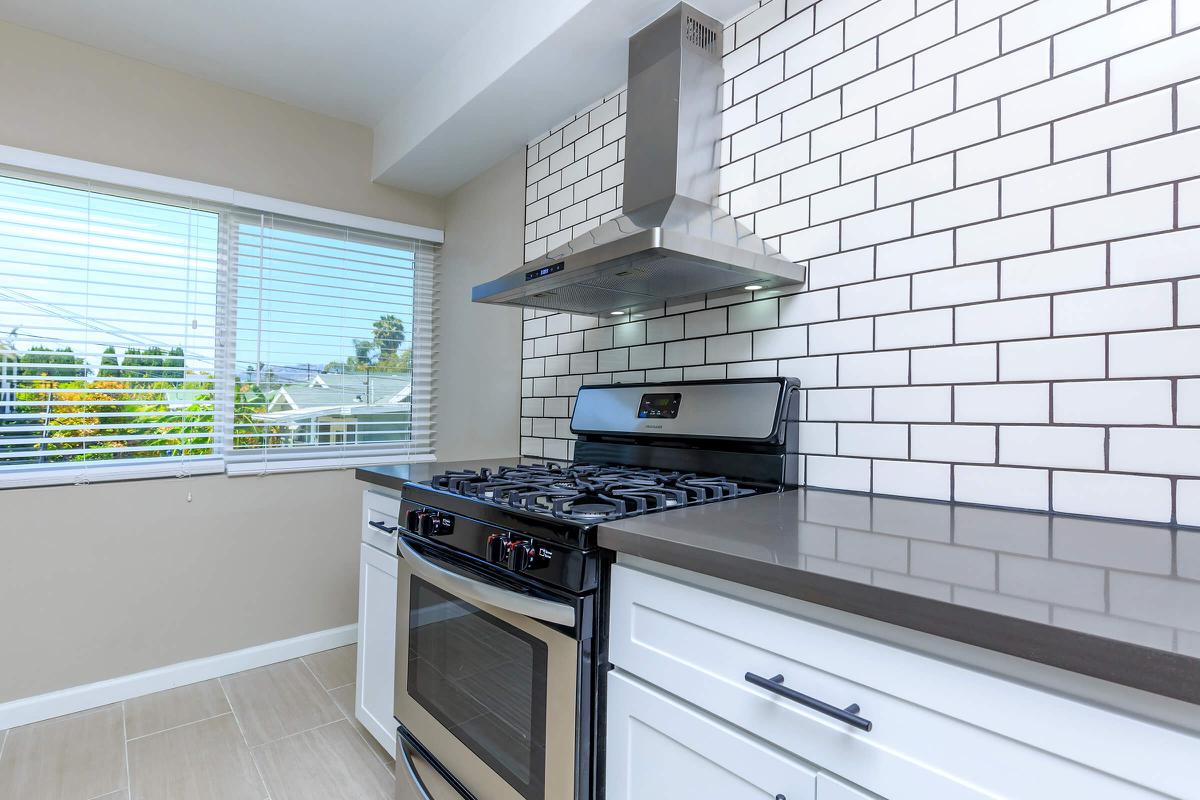 a kitchen with a stove a sink and a window