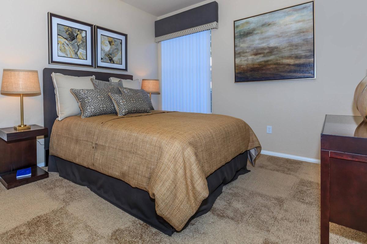 a bedroom with a bed and desk in a hotel room