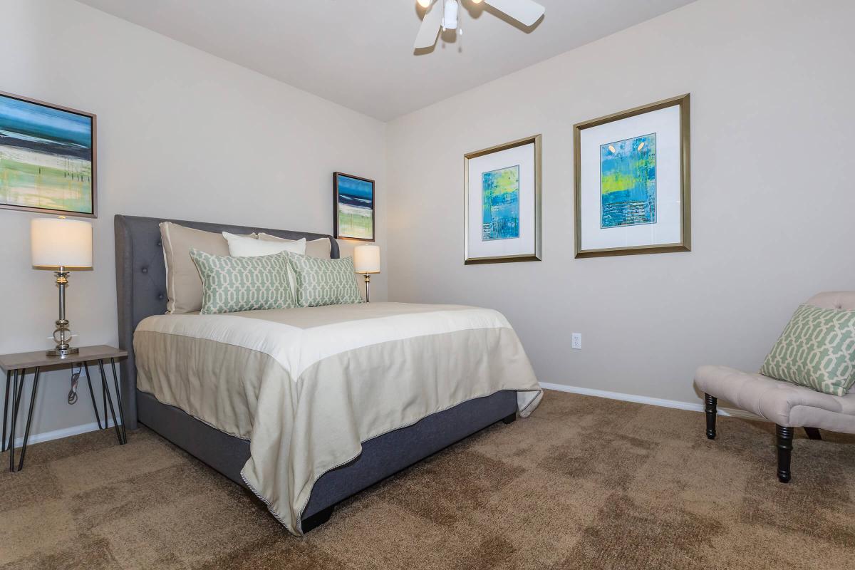 a bedroom with a bed and a chair in a room