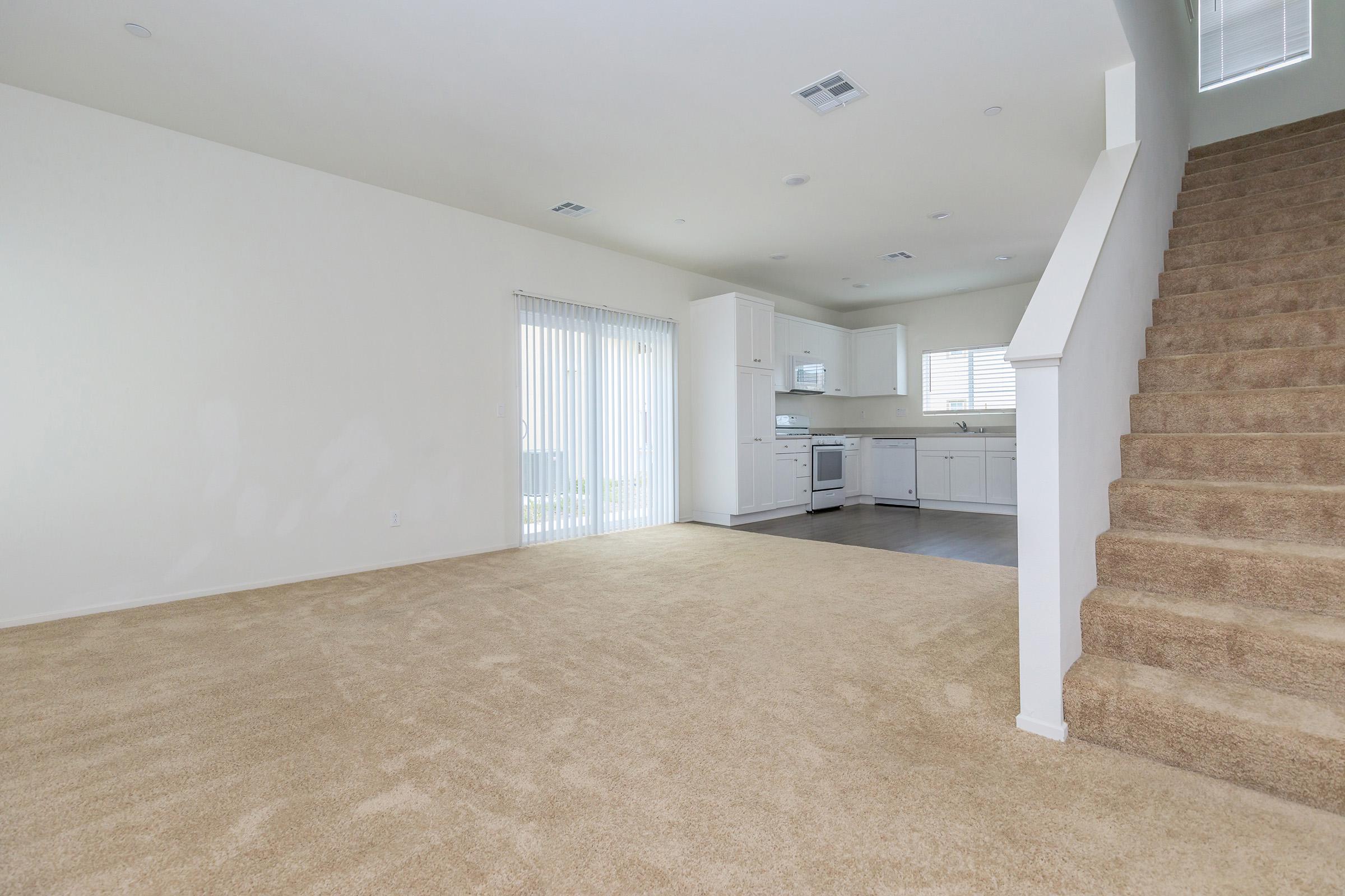 Stairs and living room with carpet