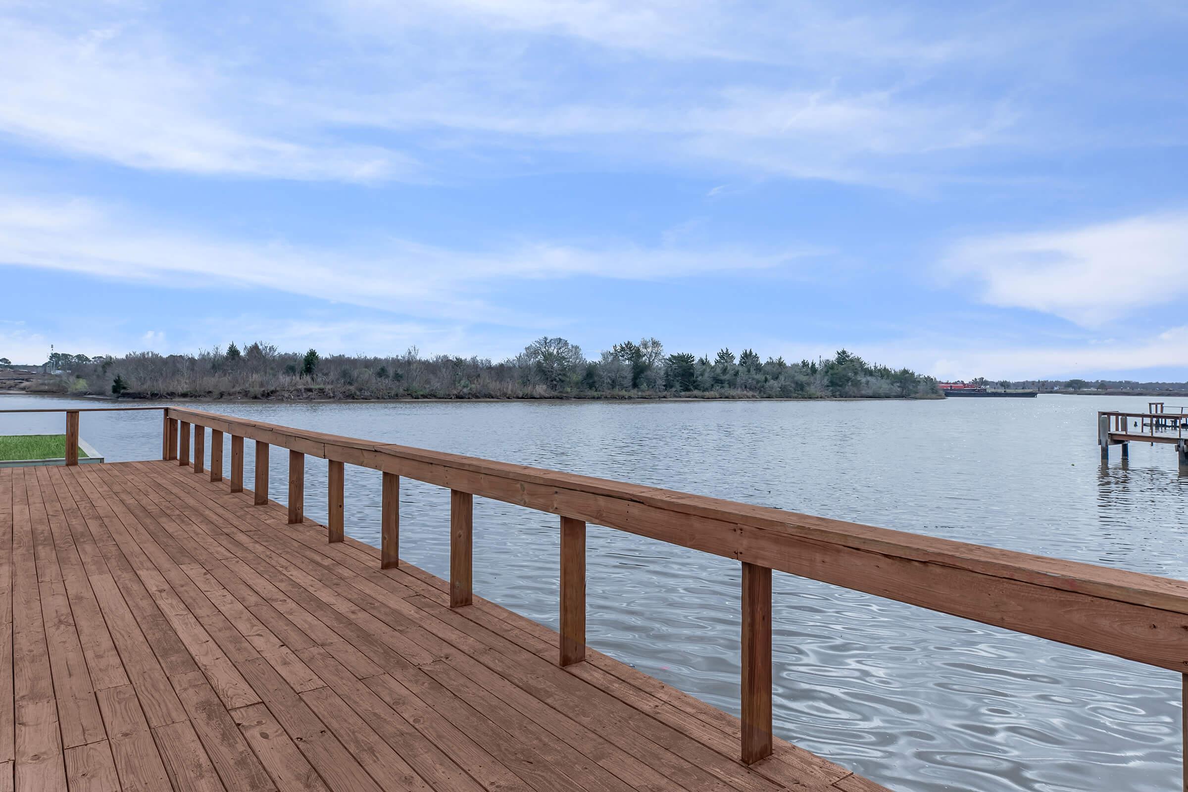 a wooden pier next to a body of water