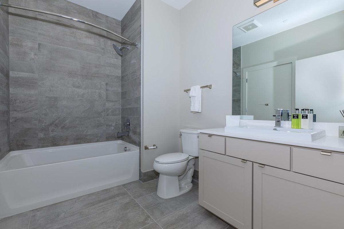 a white sink sitting under a mirror