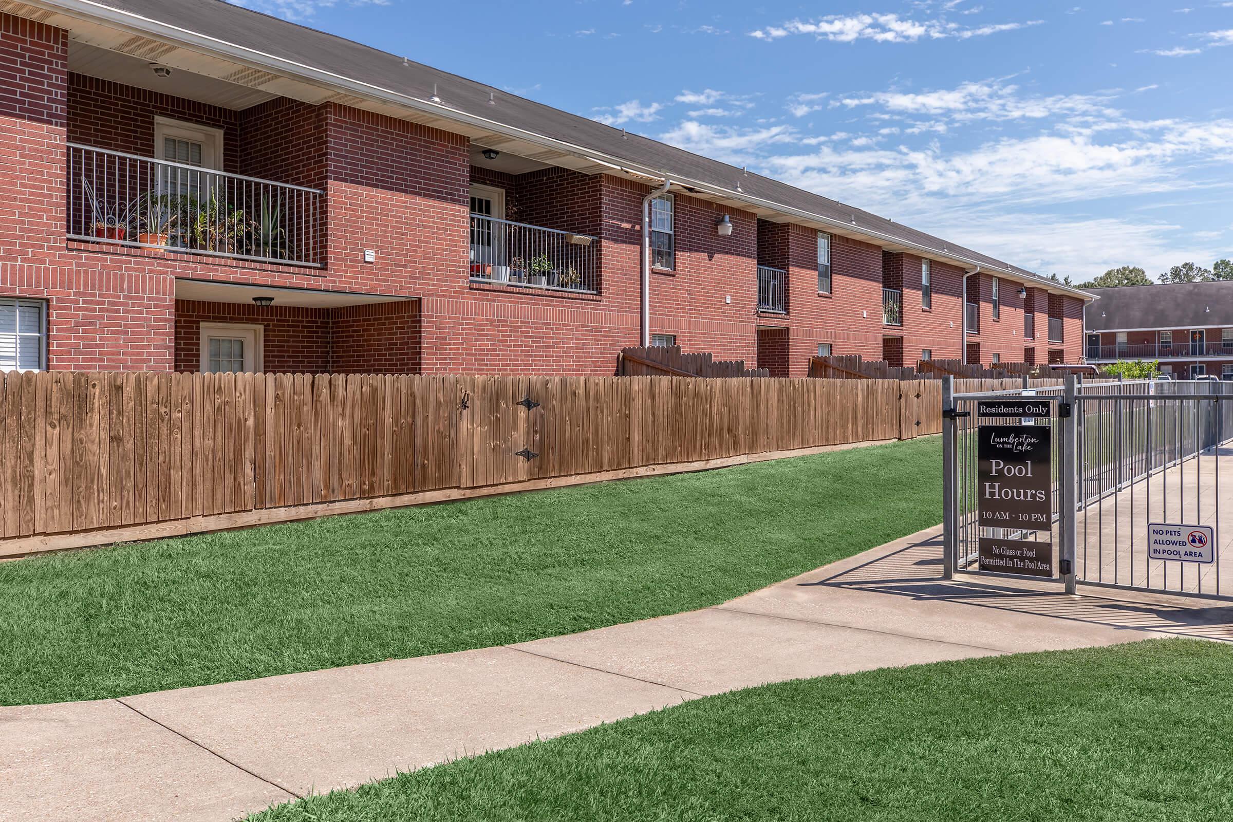 a large lawn in front of a brick building