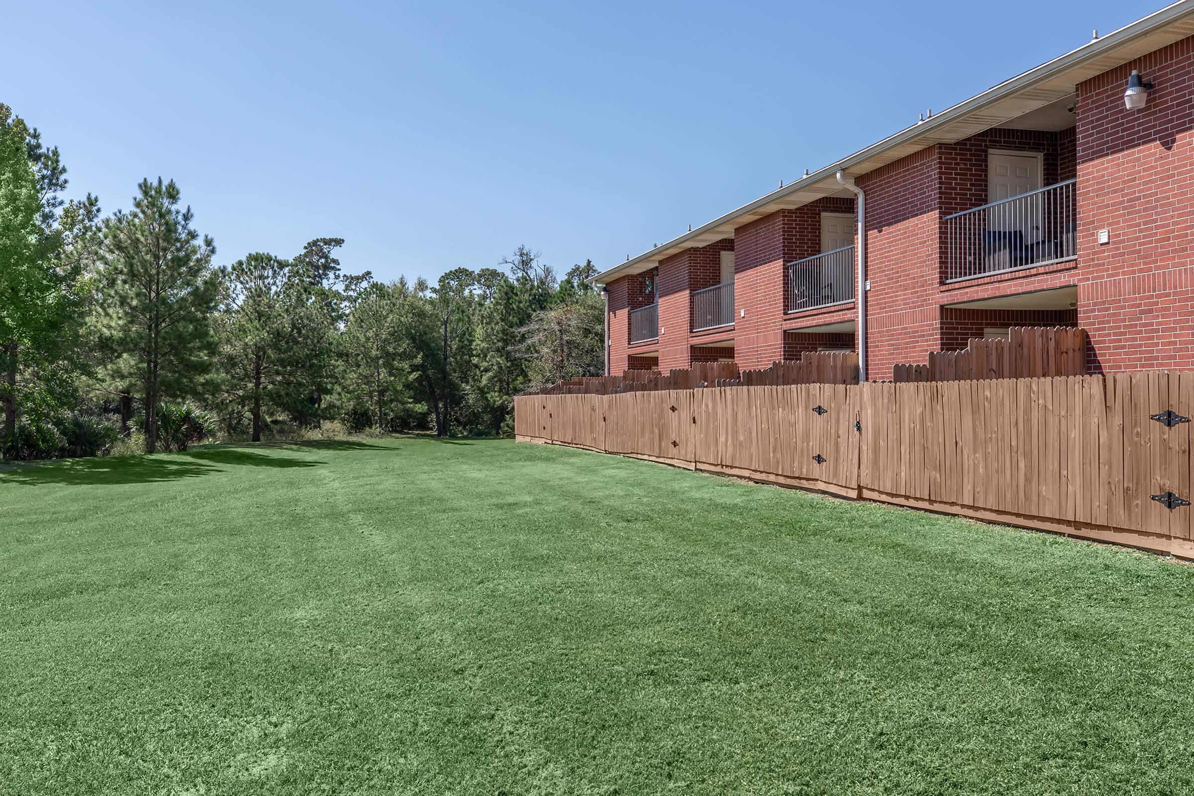 a large brick building with green grass