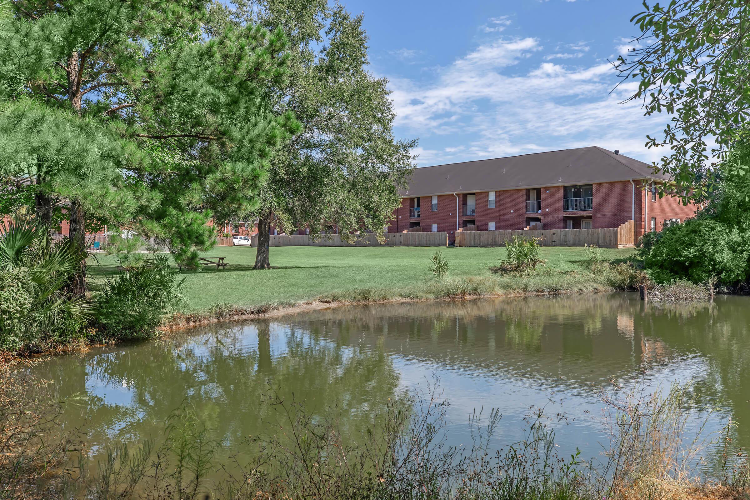 a house with a pond in front of a body of water