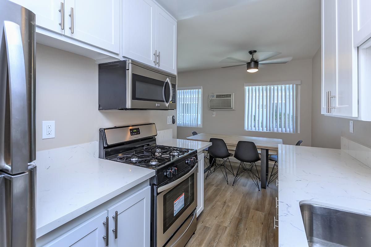 Spacious galley kitchen here at Flats on Elk that shows off the white cupboards and counters amidst the stainless appliances.