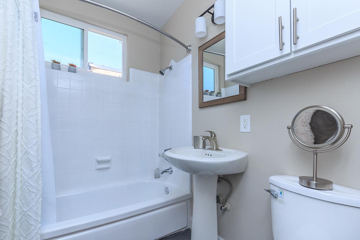 Roomy bathrooms with plenty of storage here at Flats on Elk that showcase white surrounds and white cabinets.