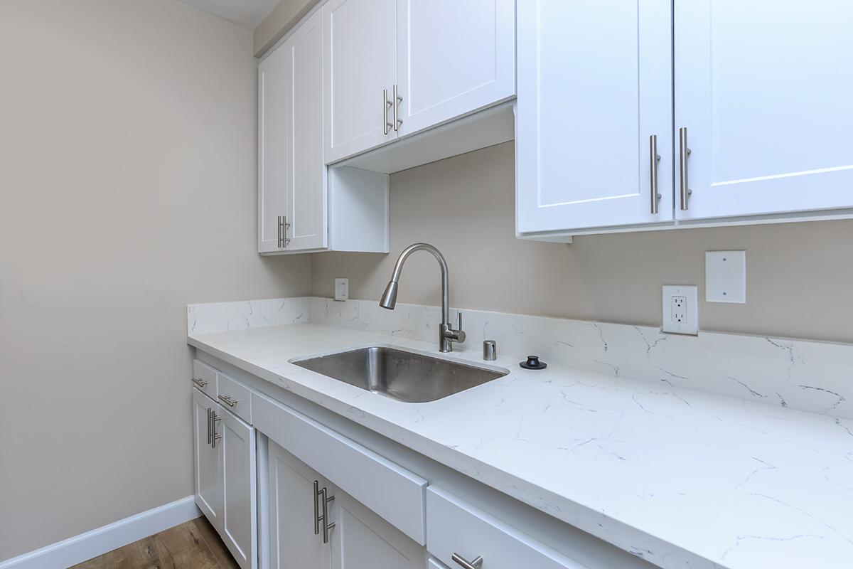 Lots of storage and counter space in fresh white here at Flats on Elk. This photo also shows the goose neck faucet.