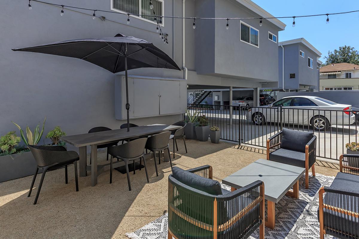 A spacious common area for Flats on Elk that has seating with and without umbrellas for shade.