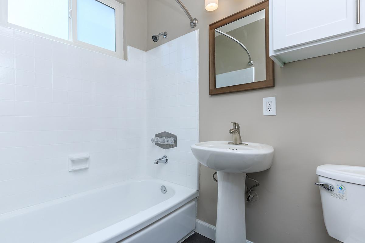 Flats on Elk has the most beautiful bathrooms with white surrounds in the tub shower combo and cabinets for storage over the commode along with a window and plenty of lighting here at Flats on Elk.