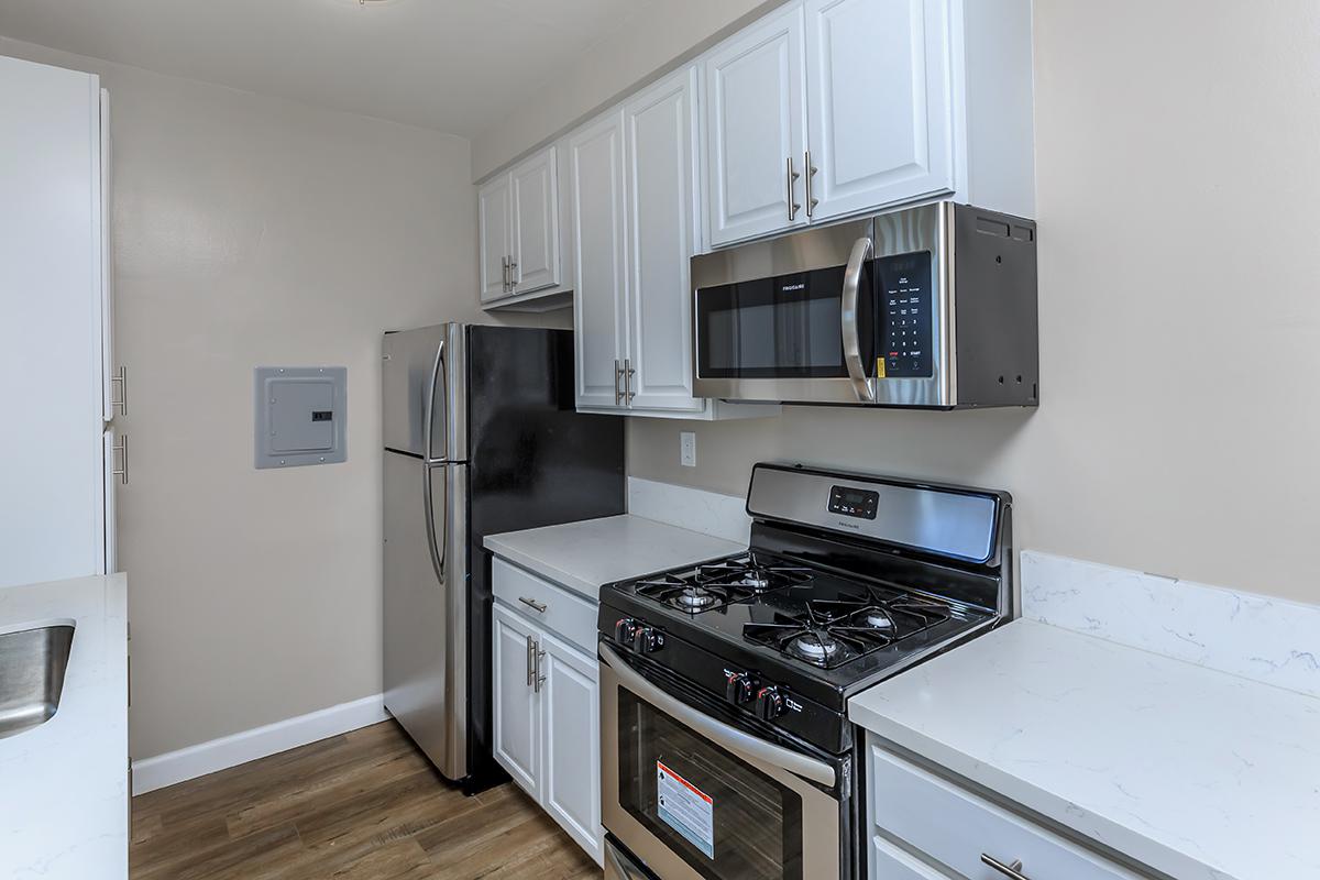 Stainless appliances nestled amongst the white cabinets and countertops here at Flats on Elk 