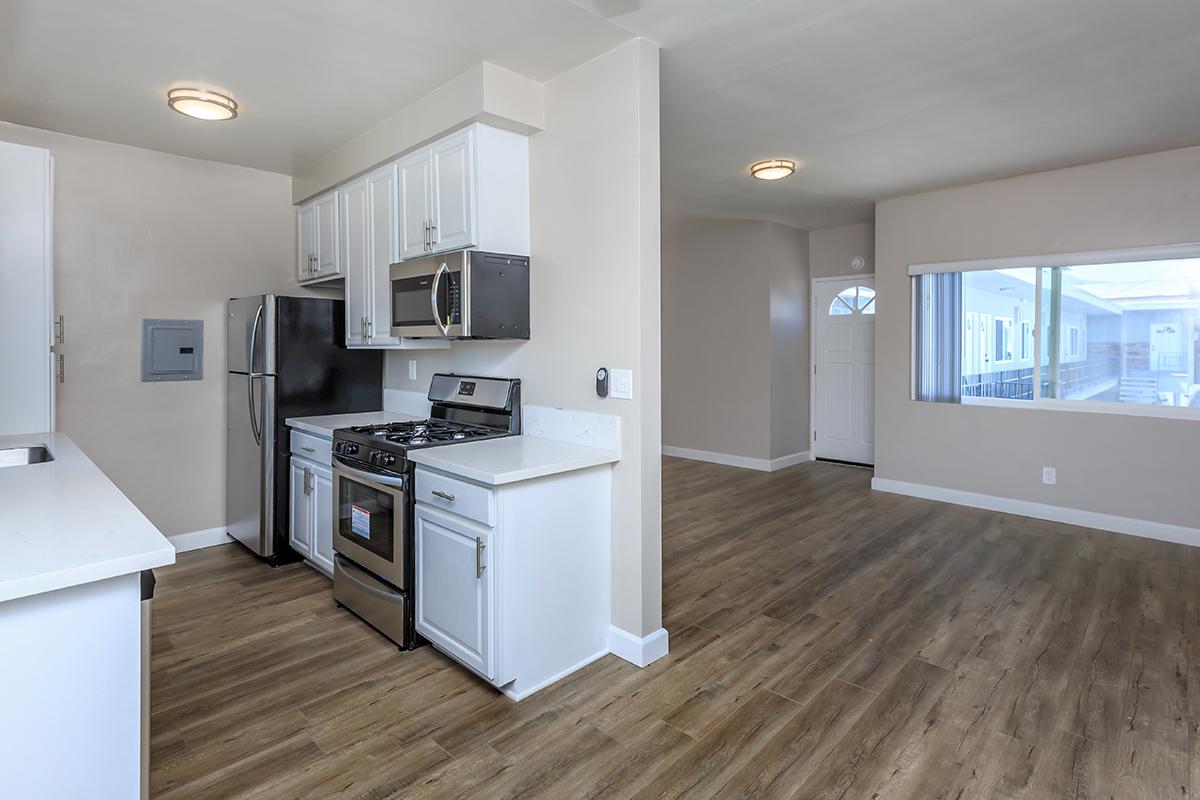 Stunning wood-like floors make the white cabinets and countertops pop, which naturally makes the stainless appliances look marvelous here at Flats on Elk.