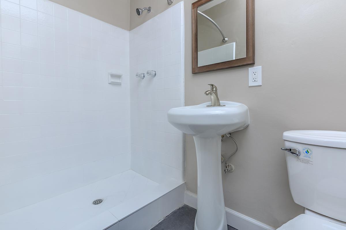 This bathroom photo shows a white surround in a shower only at Flats on Elk.