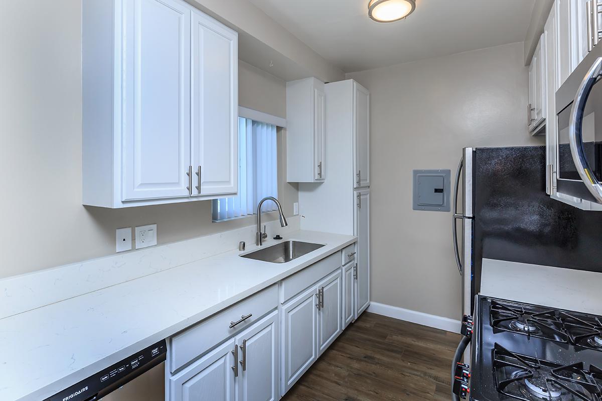 White counter space and cabinets with a goose neck faucet here at Flats on Elk