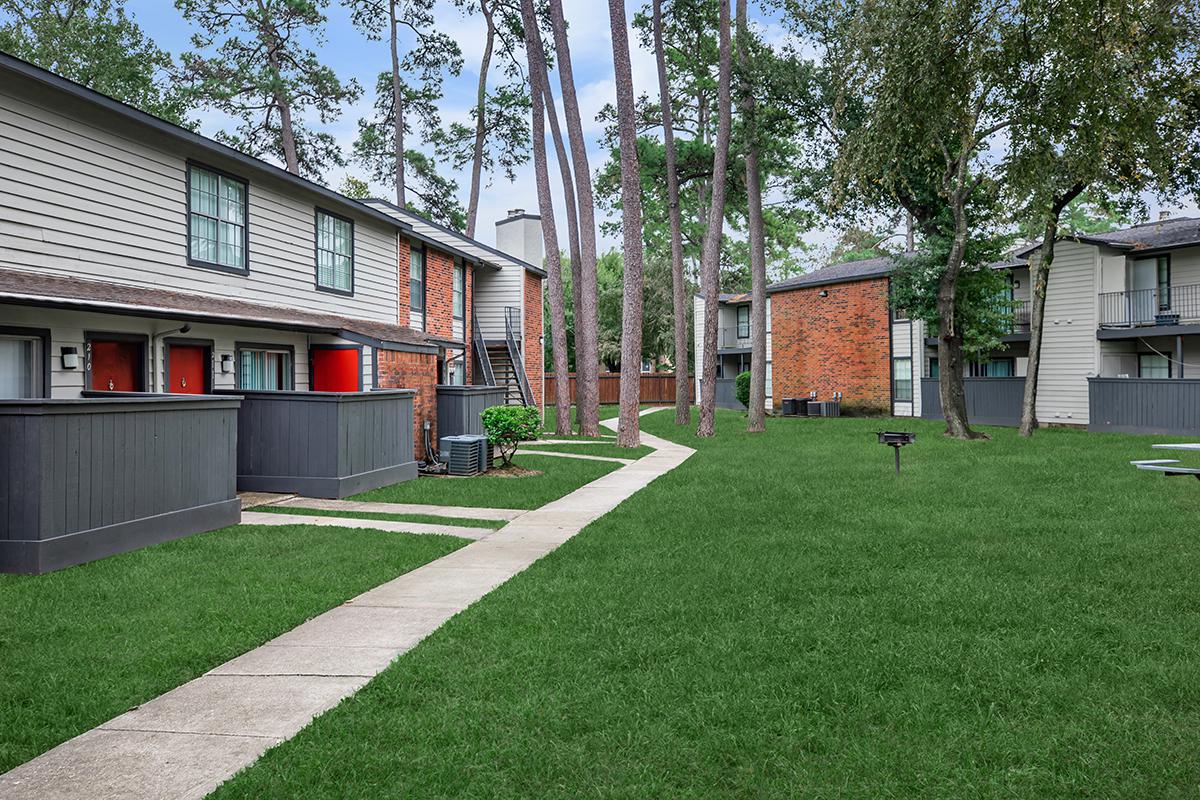 a house with a lawn in front of a brick building