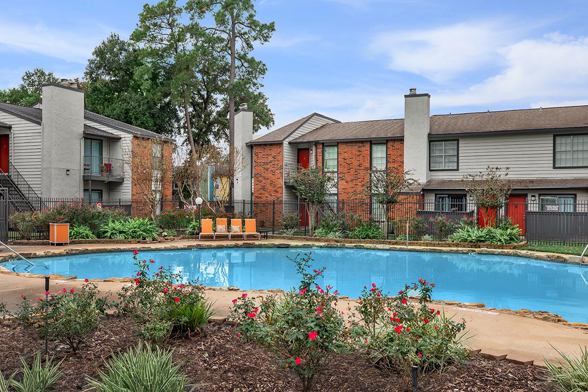 a garden with water in front of a house