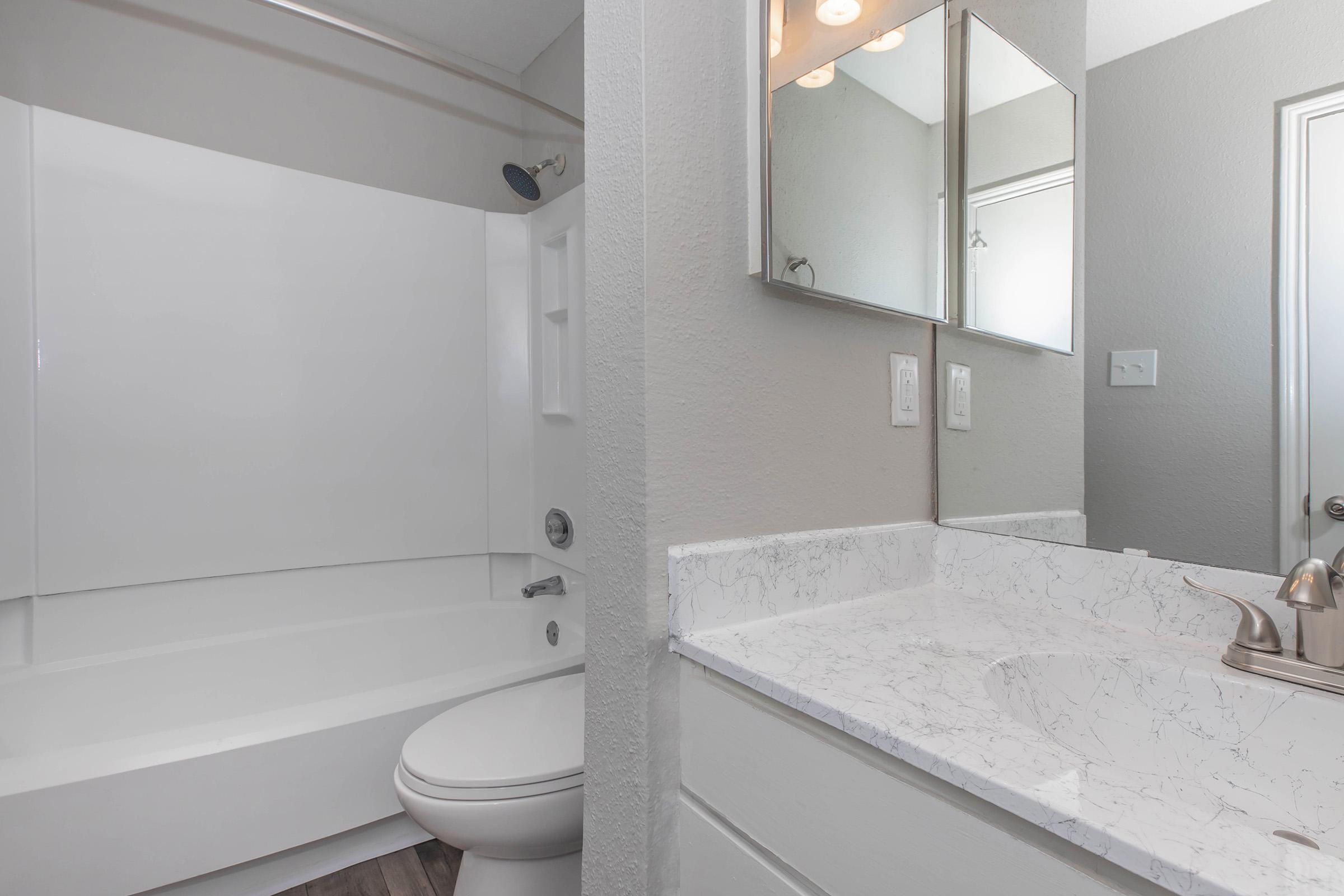 a white sink sitting under a mirror