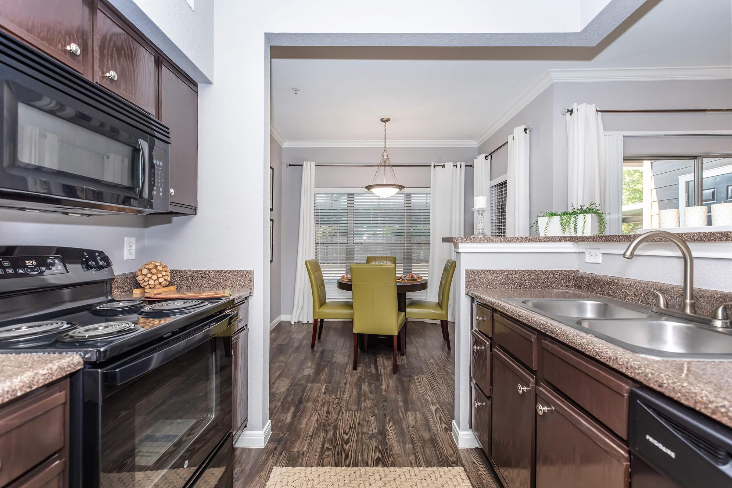 a kitchen with a stove a sink and a window