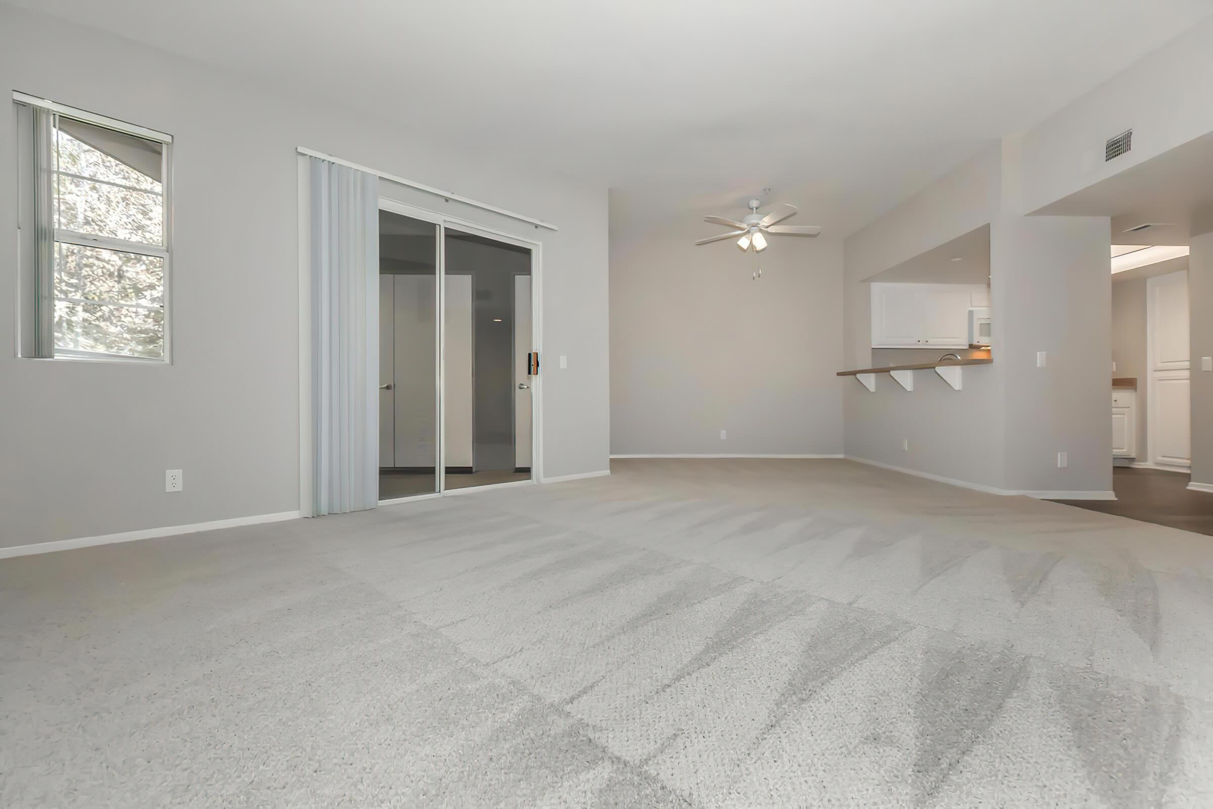 Vacant living room with carpet and sliding glass doors