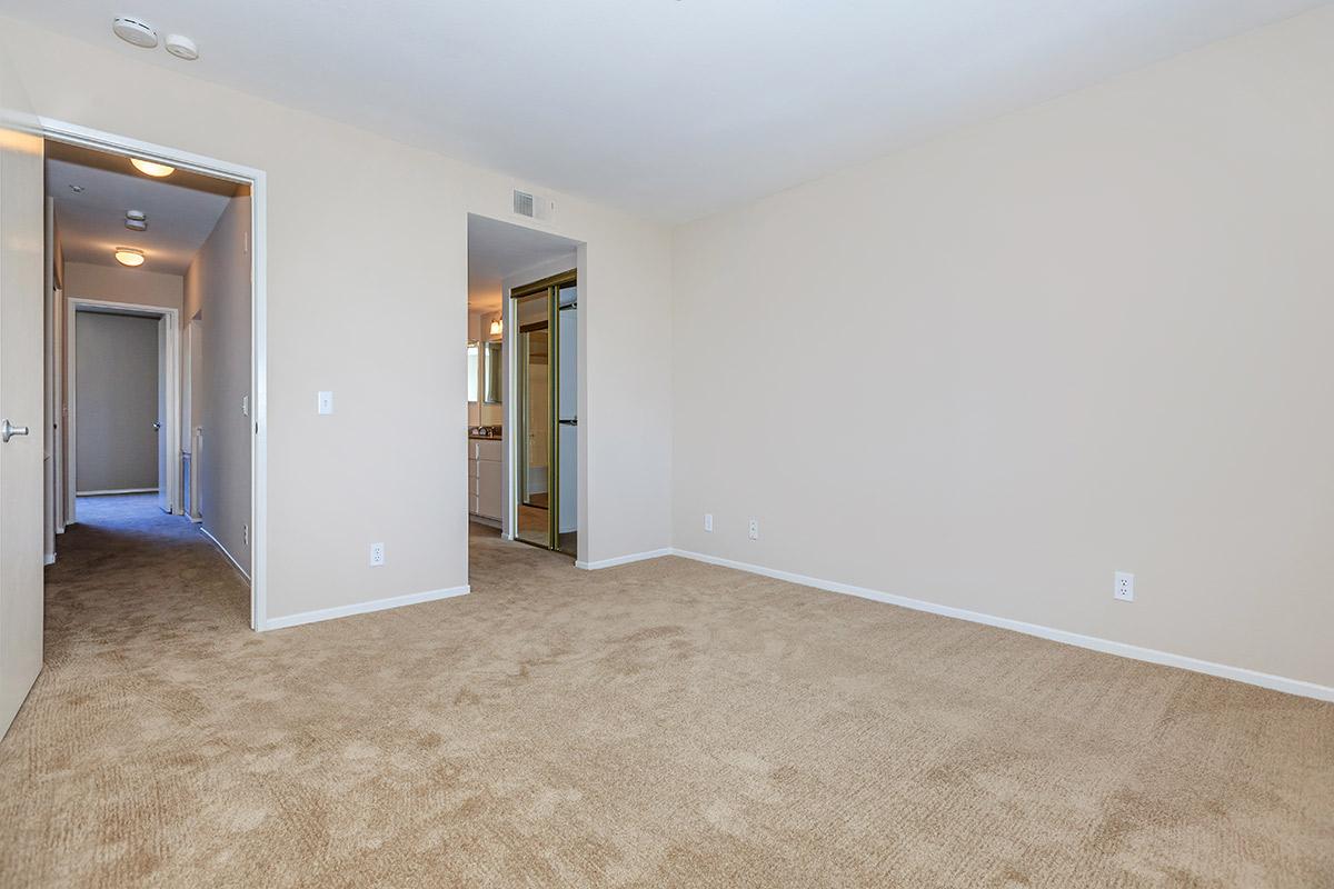 Vacant bedroom with open sliding closet doors