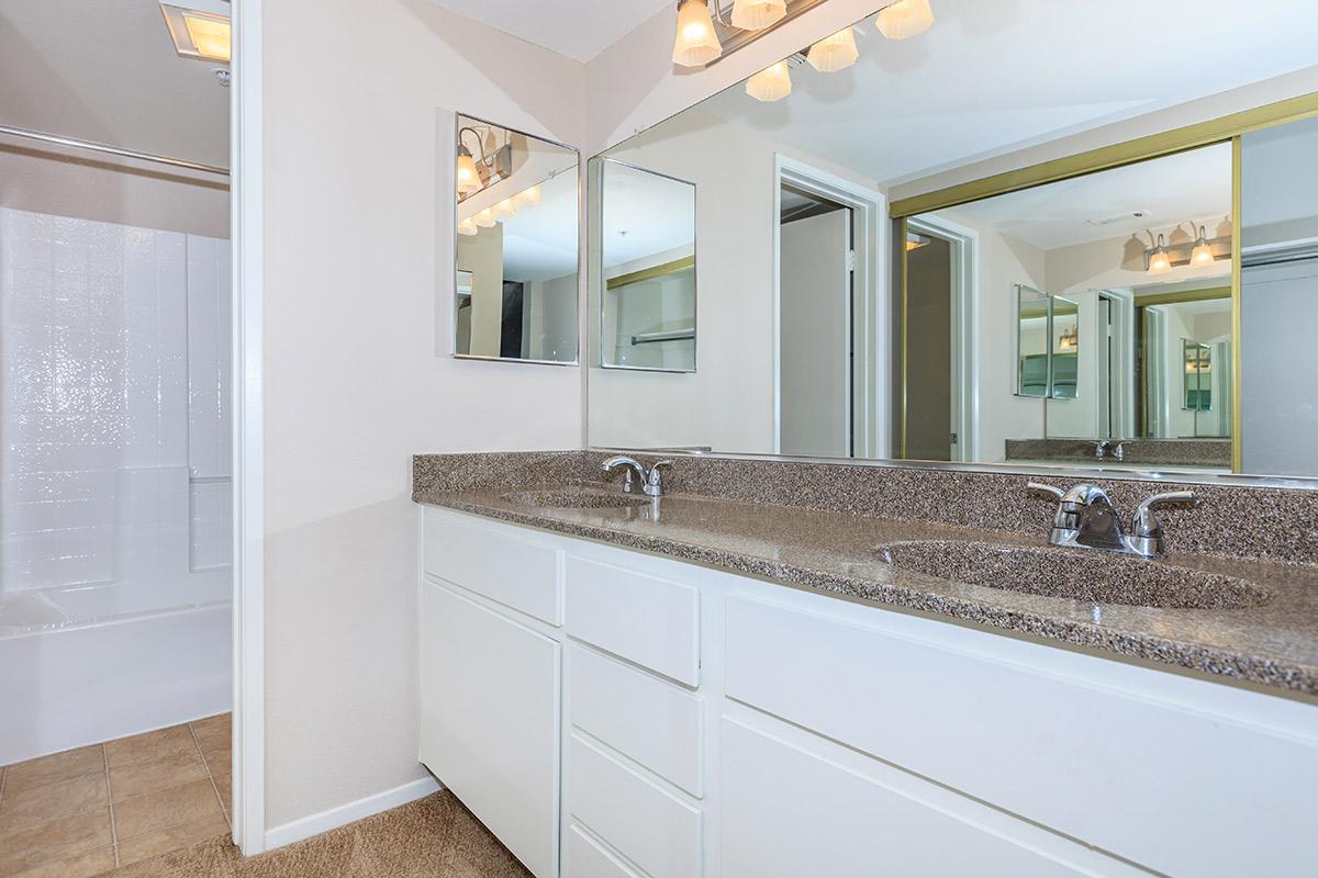 Two bathroom sinks with white cabinets