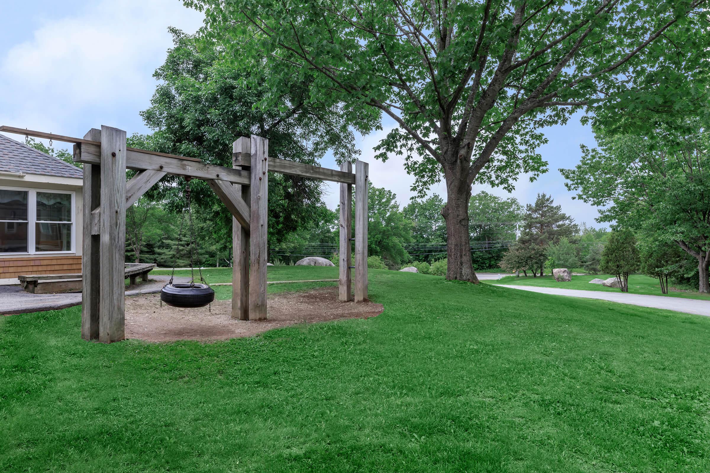 a couple of lawn chairs sitting on top of a grass covered park