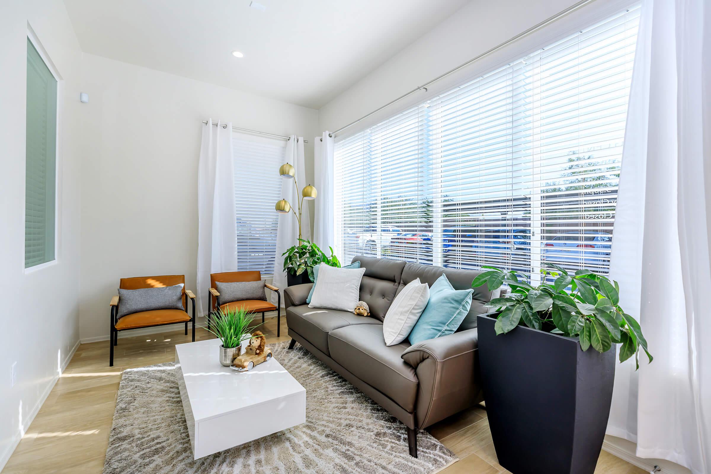 a living room filled with furniture and a large window