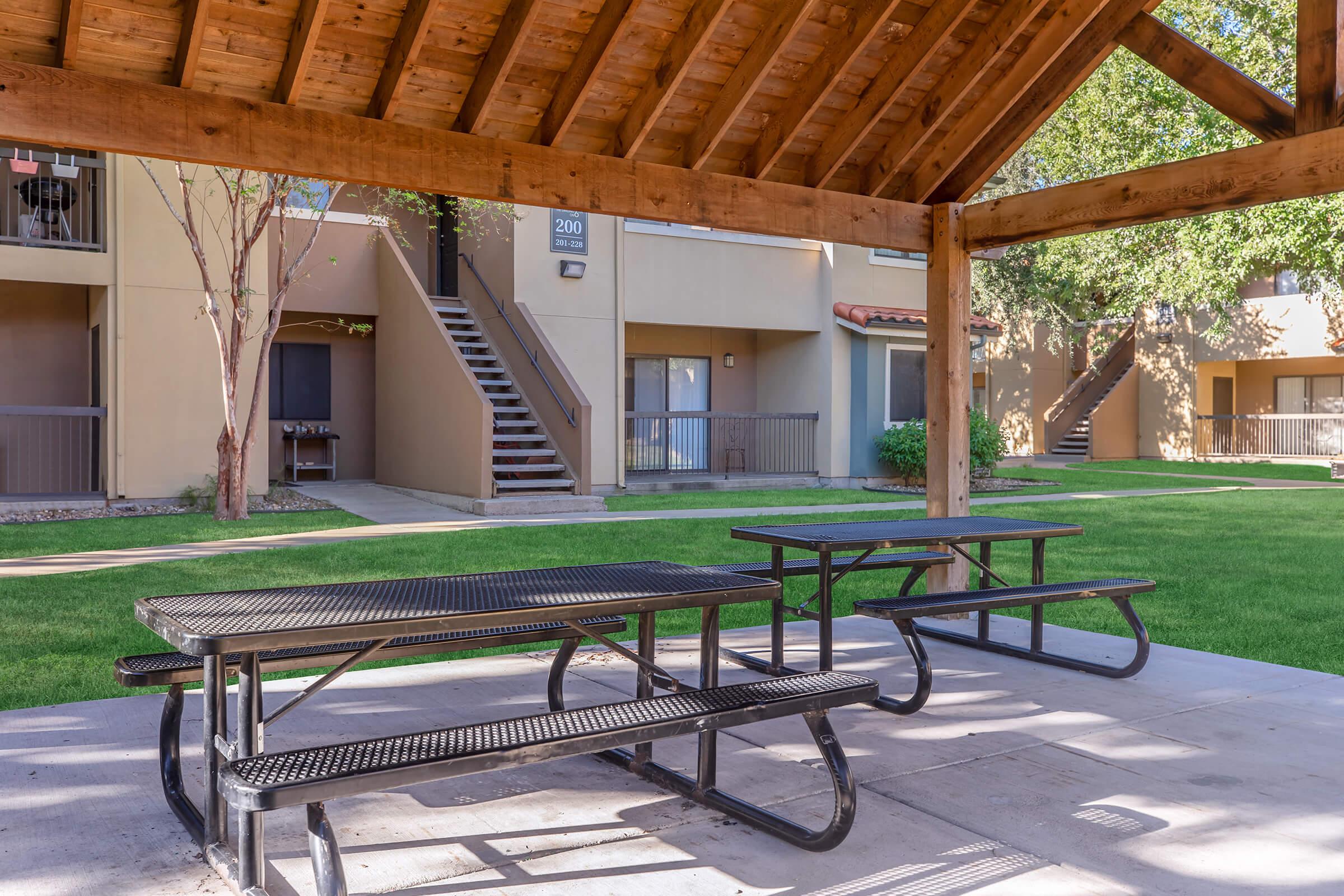 a wooden bench sitting in front of a picnic table