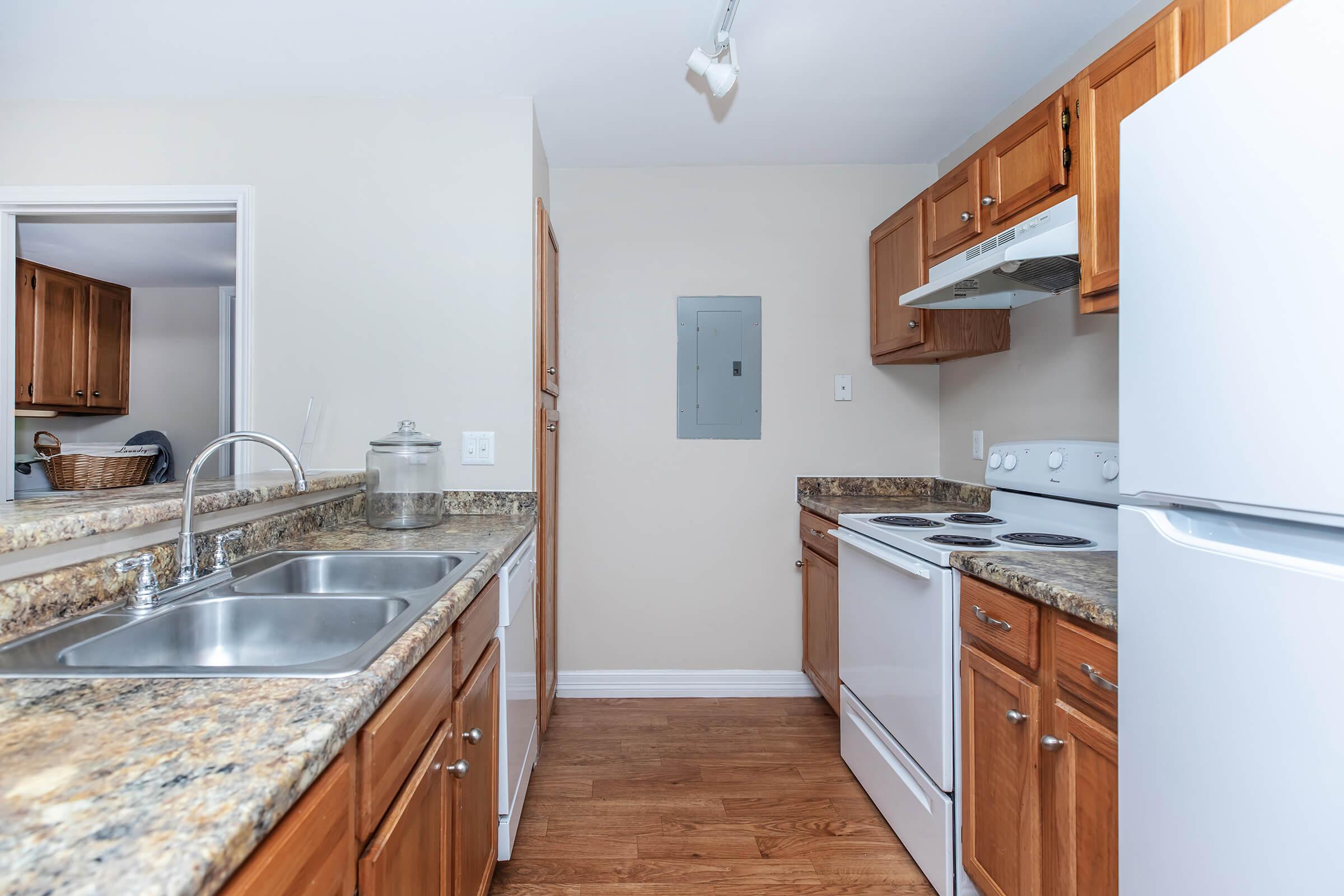 a large kitchen with stainless steel appliances and wooden cabinets